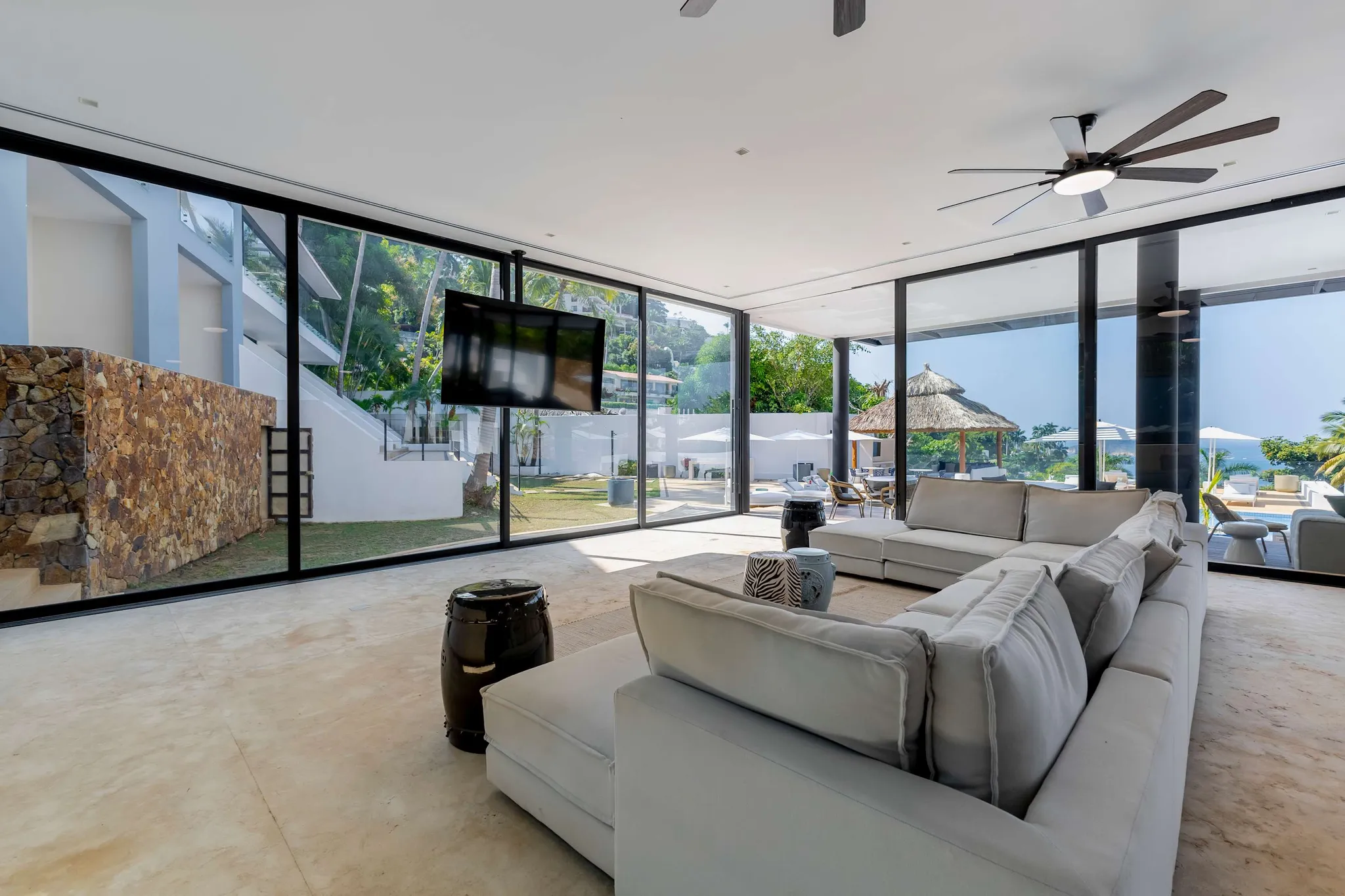 A spacious living room with a large white sectional sofa and a TV.