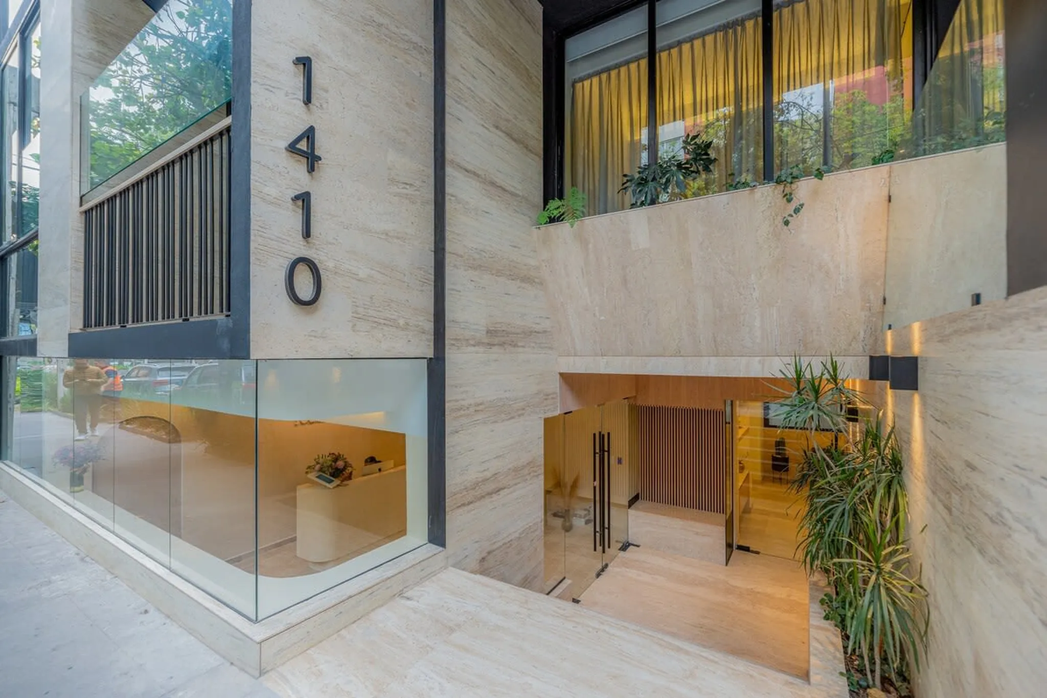 Modern building entrance with address numbers 1410 and glass details.