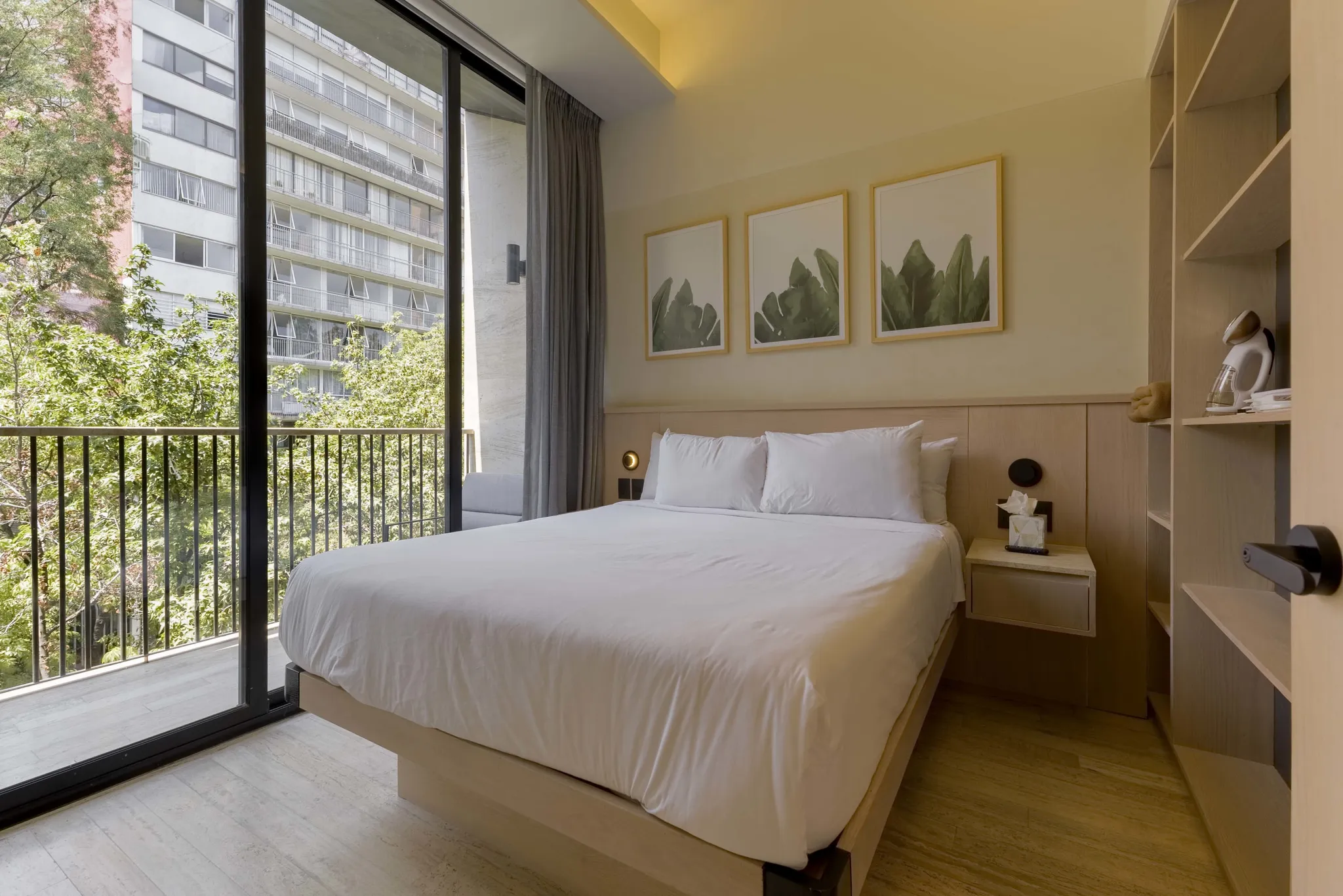 A hotel room with a king size bed and a balcony view.
