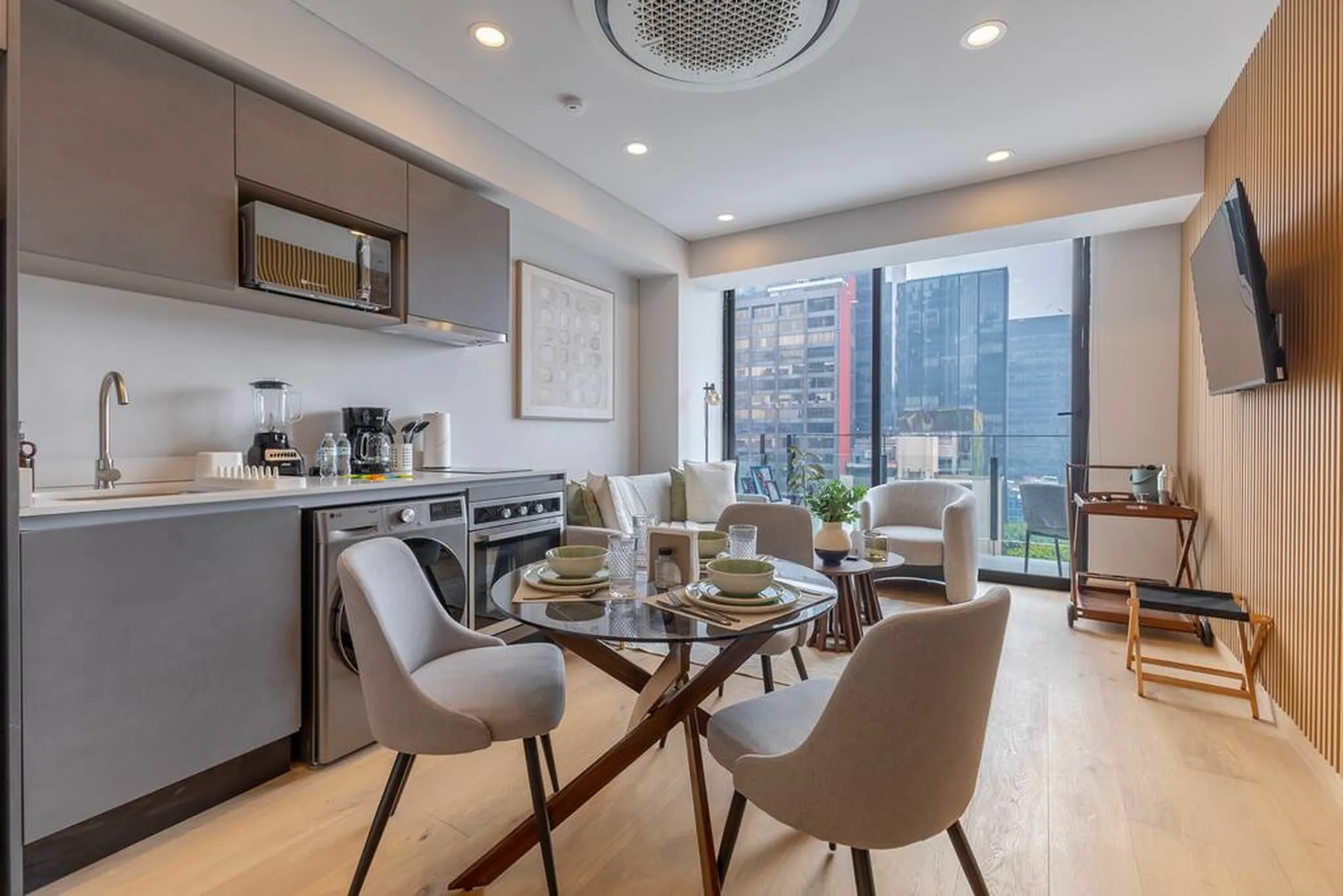 Modern apartment with open kitchen, dining area, and living space with city views.
