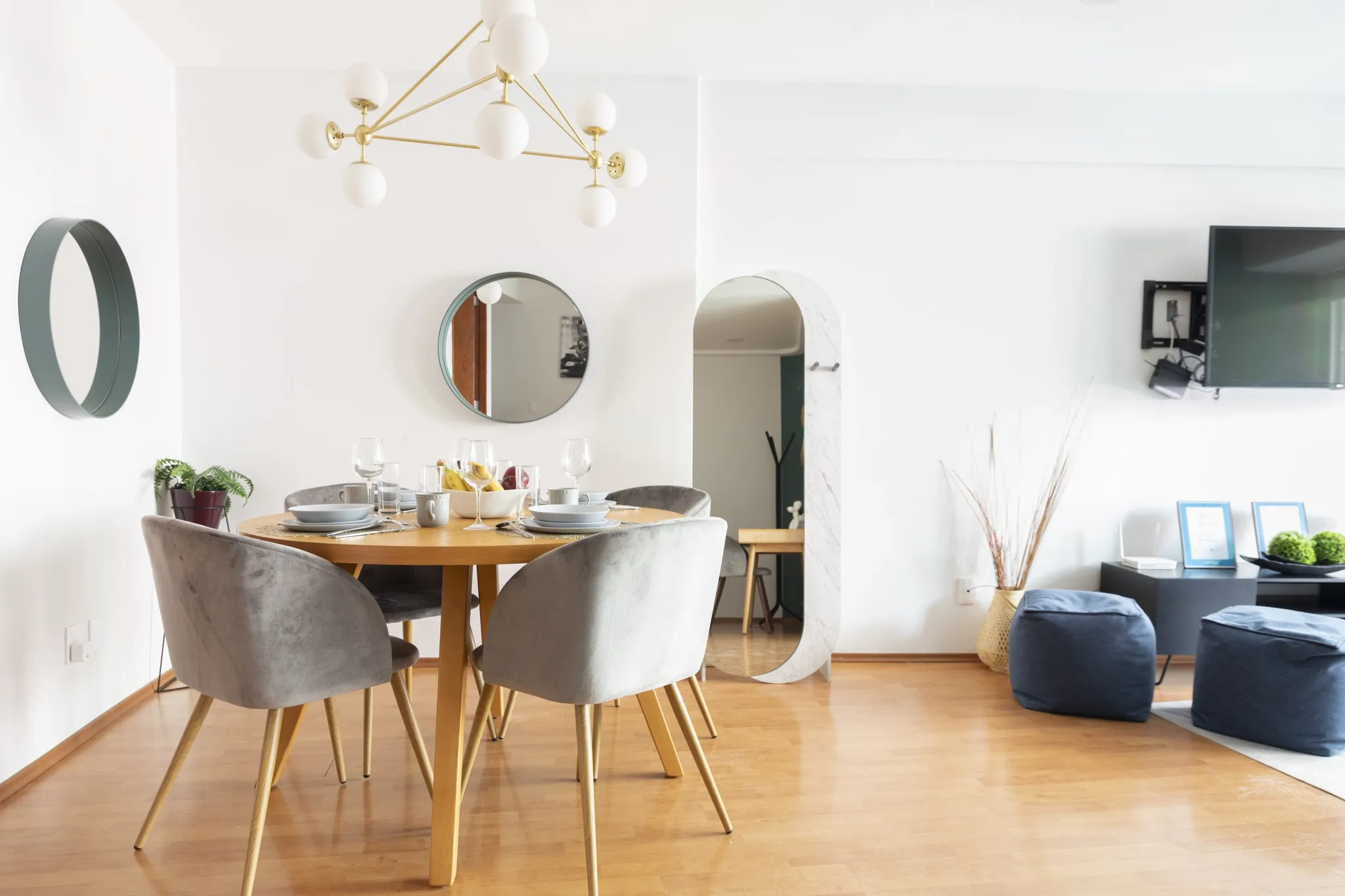Dining room with chairs, table, and decorative mirrors.