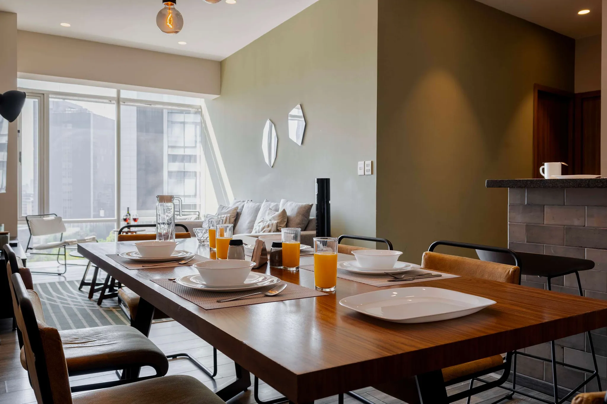 A dining table is set for a meal with place settings and drinks.