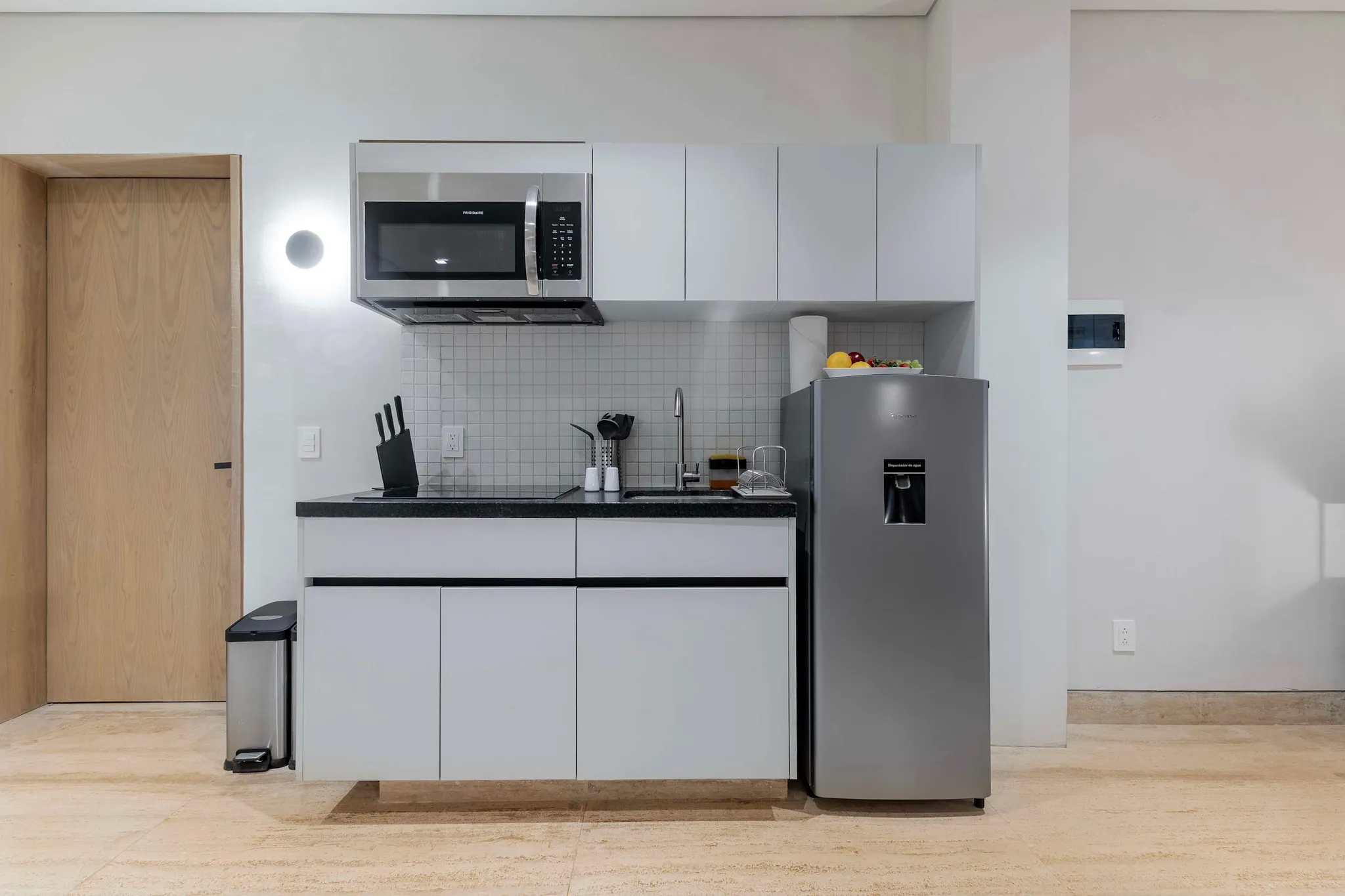 Kitchen with microwave, refrigerator, sink, and cabinets.