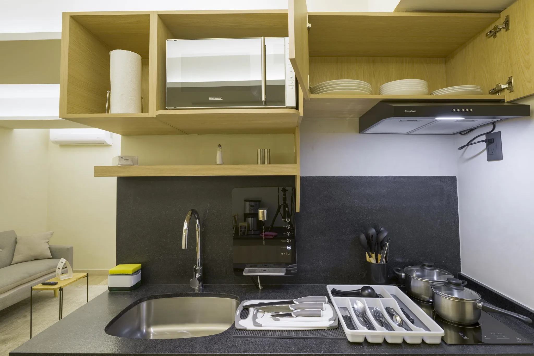 A modern kitchen with wooden cabinets, a microwave, and a granite countertop.