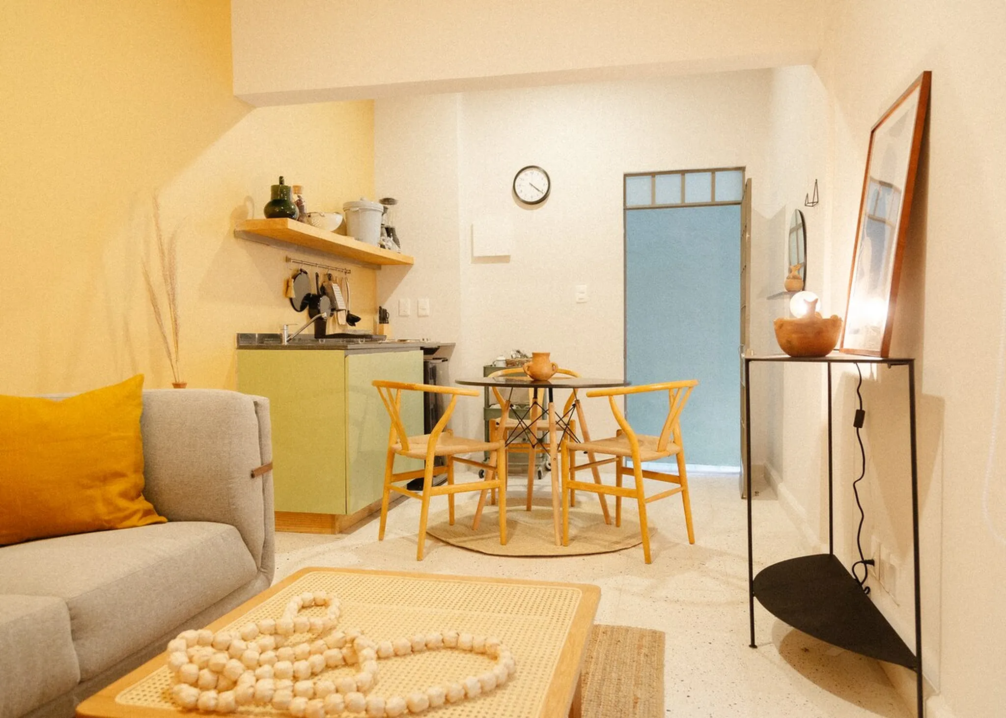 Cozy living room with yellow accents and a minimalist dining area.