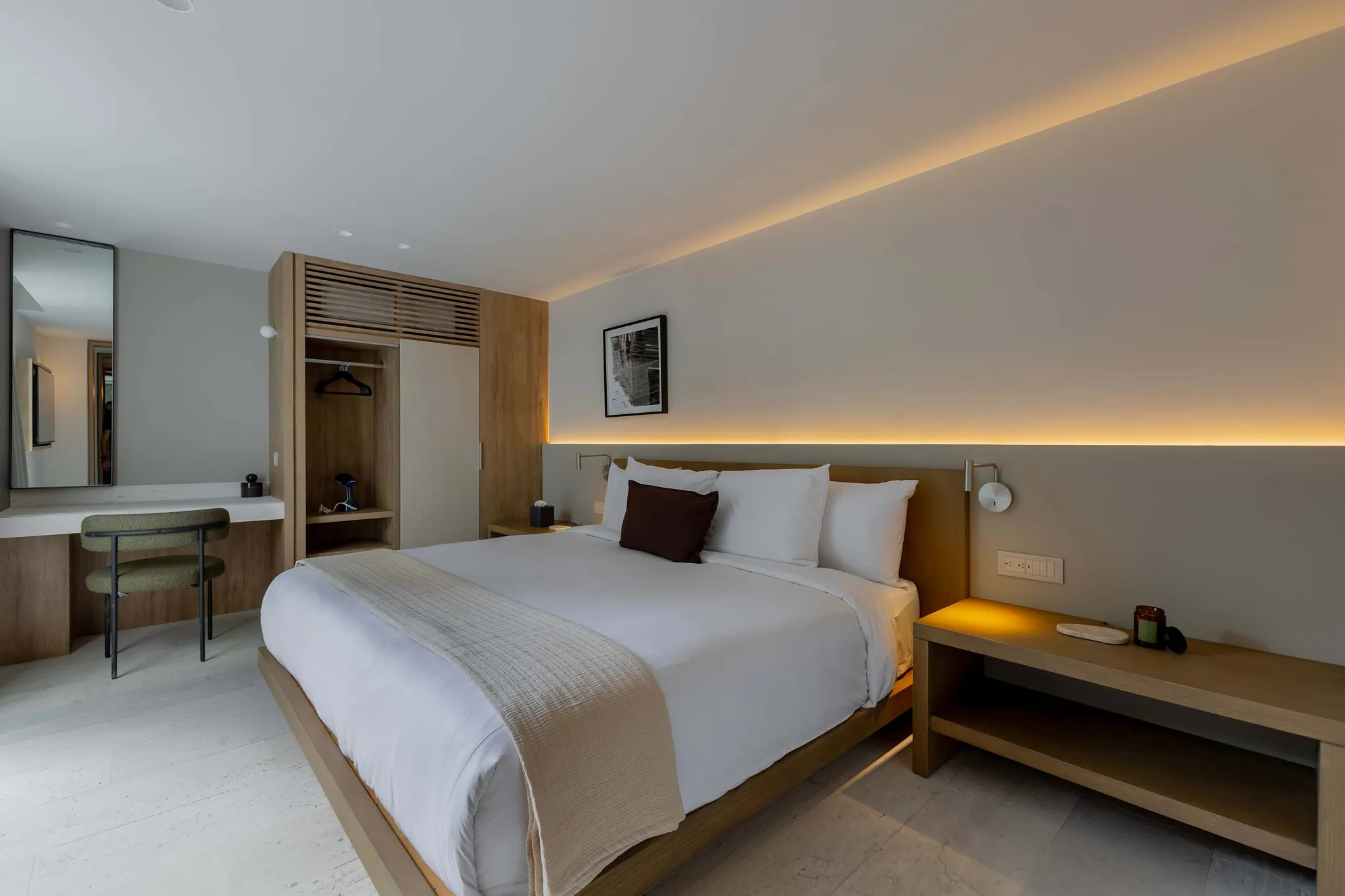 A stylish bedroom with a bed, a vanity, and a closet.
