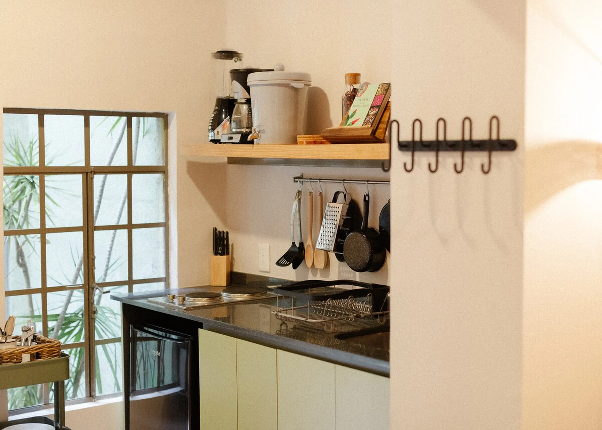 Kitchen interior with a window, a coffee maker, and utensils.