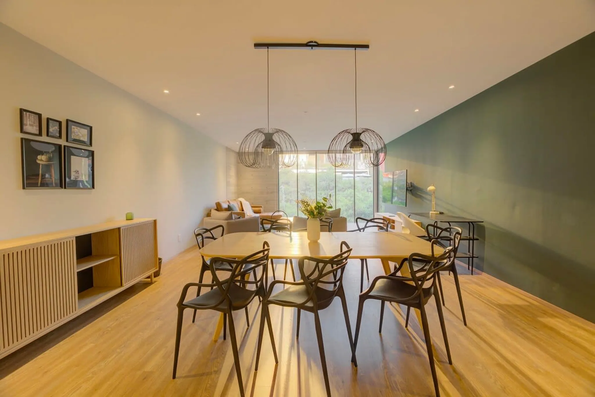 A dining room with a light wood floor and chairs.