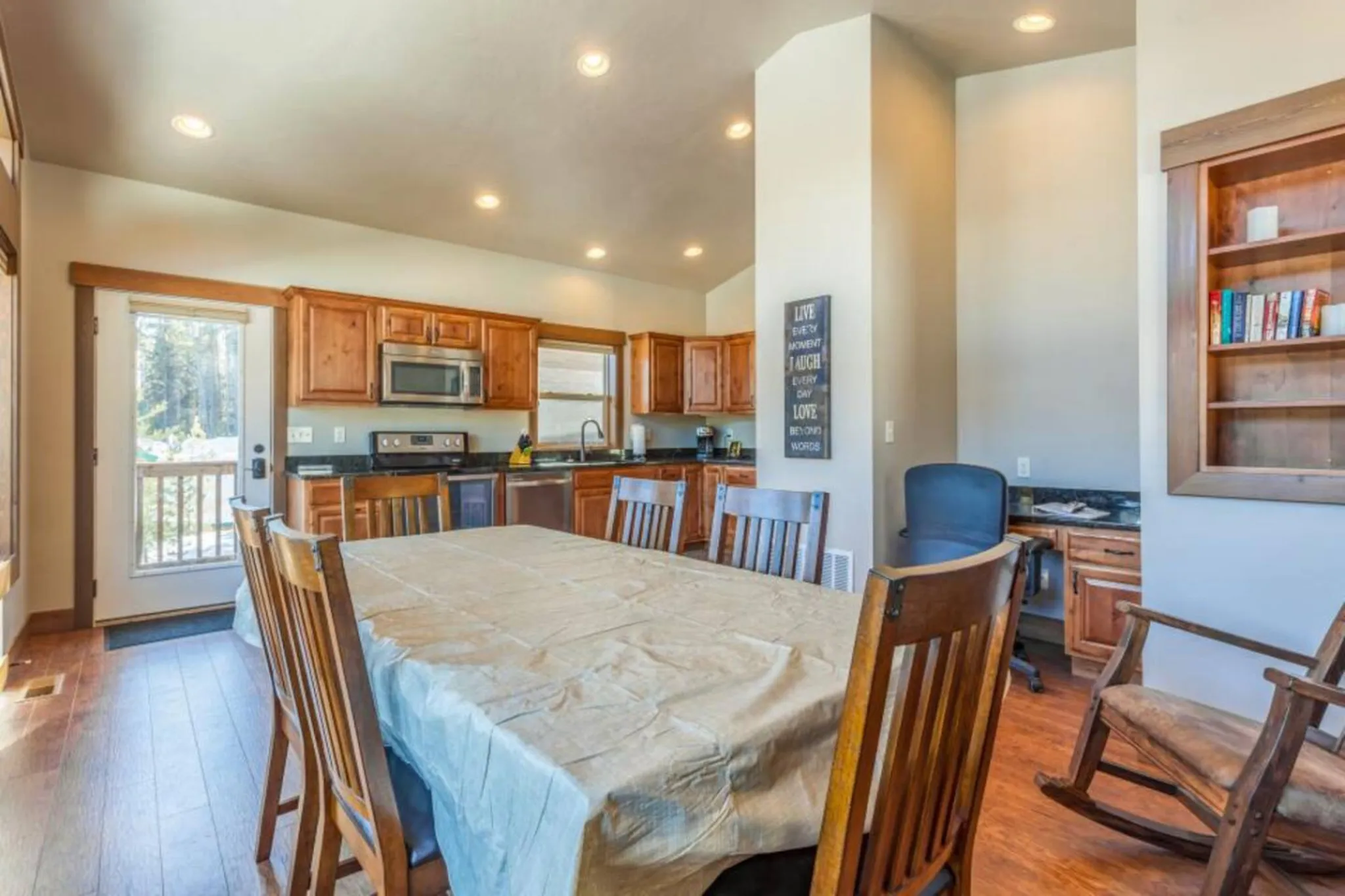 A spacious dining area with a table and chairs is adjacent to a well-equipped kitchen.