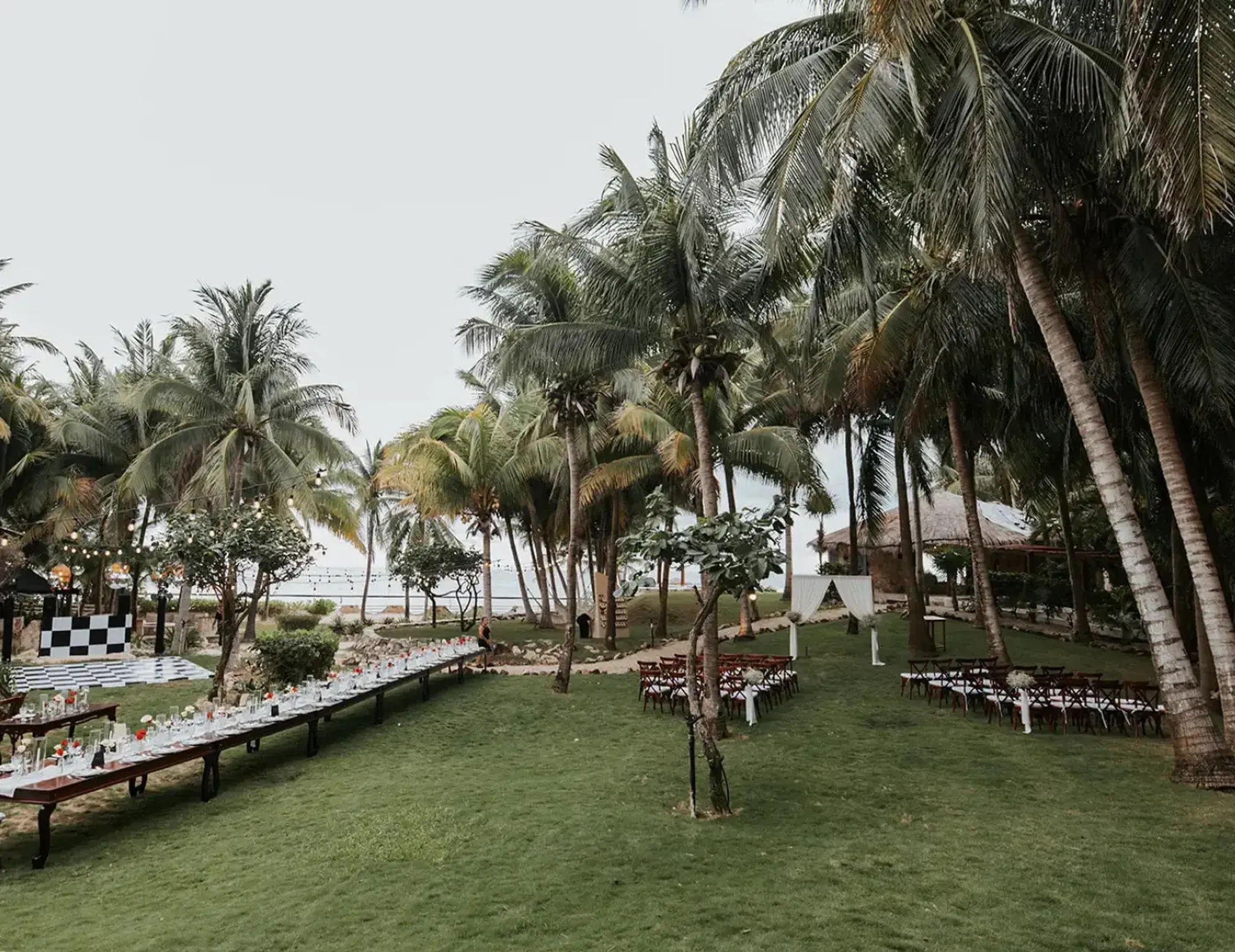Elegant beachfront garden wedding decoration setup with floral arrangements and ocean view in Riviera Maya