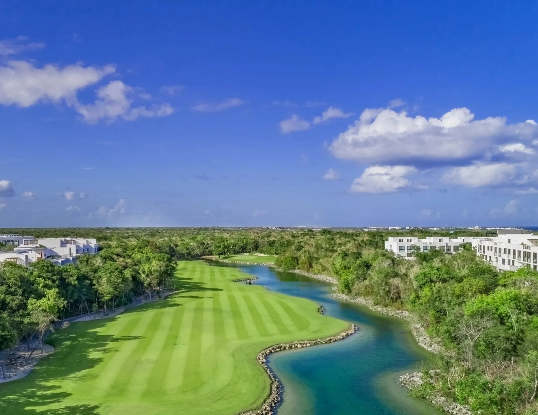 Aerial view of a luxury golf course with lagoon in Riviera Maya