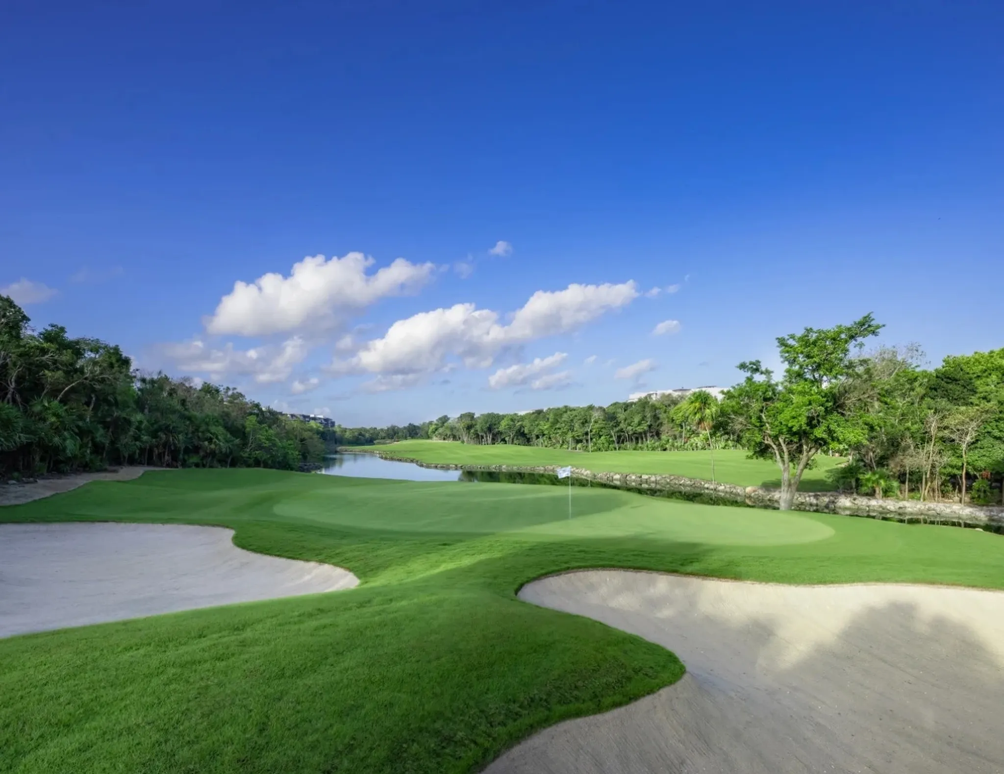Golf course fairway with lagoon surrounded by nature in Riviera Maya