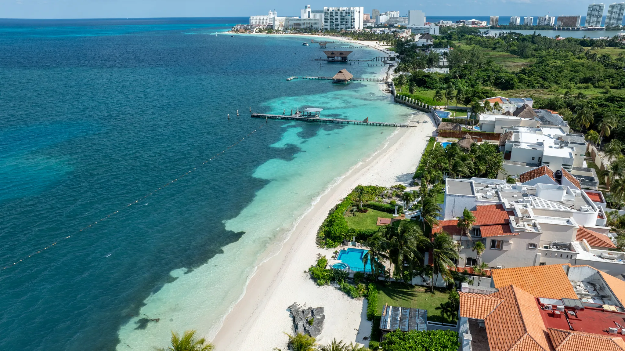 Aerial view of beachfront villas and turquoise Caribbean coastline in Cancún