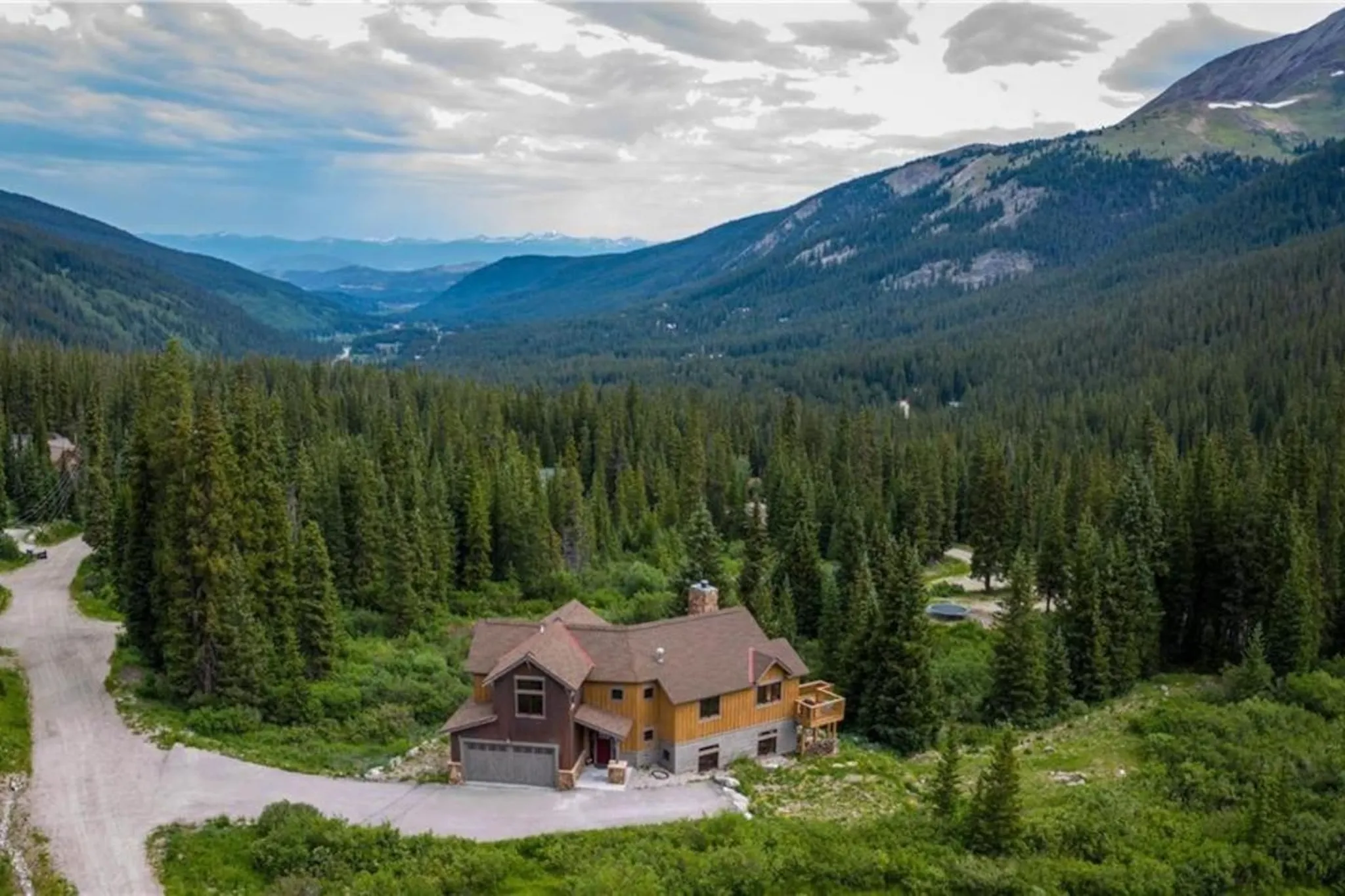 Blue River House, a Luxe Living home in Breckenridge, in a green valley below forested peaks