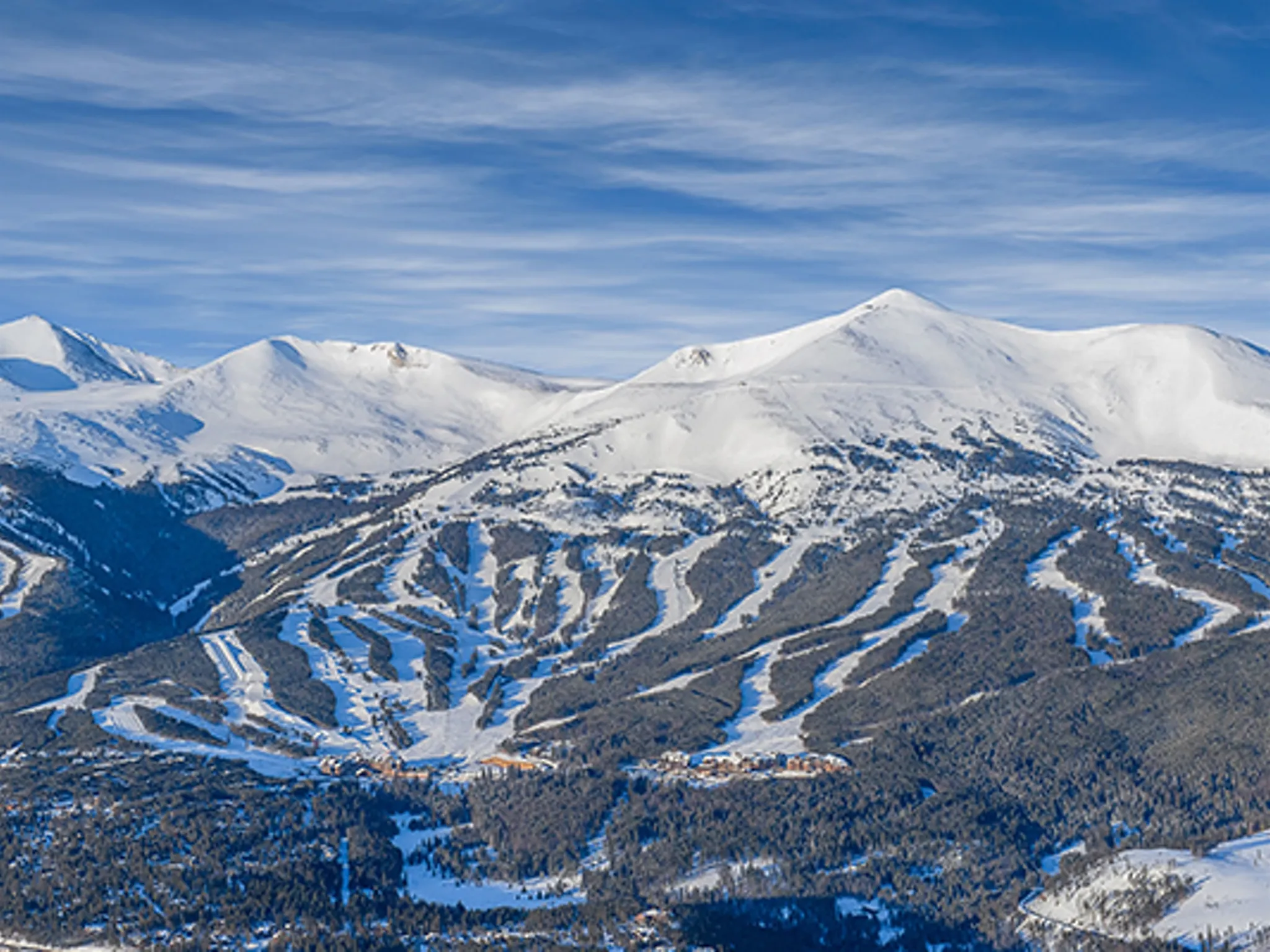 Breckenridge ski area above the snow-covered valley and pine forest, from the Atrium at Altitude listing