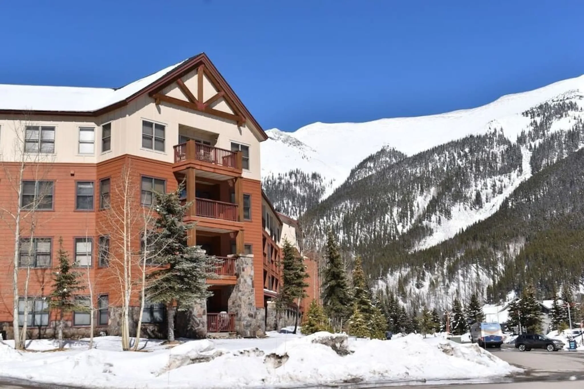 Copper Springs lodge building in front of the snow-covered ski runs at Copper Mountain