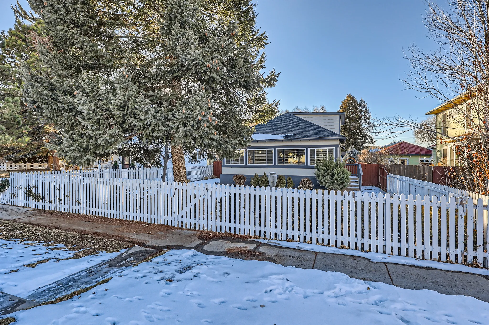 Tranquila Casa, a Luxe Living cottage in Castle Rock, behind a white picket fence in fresh snow