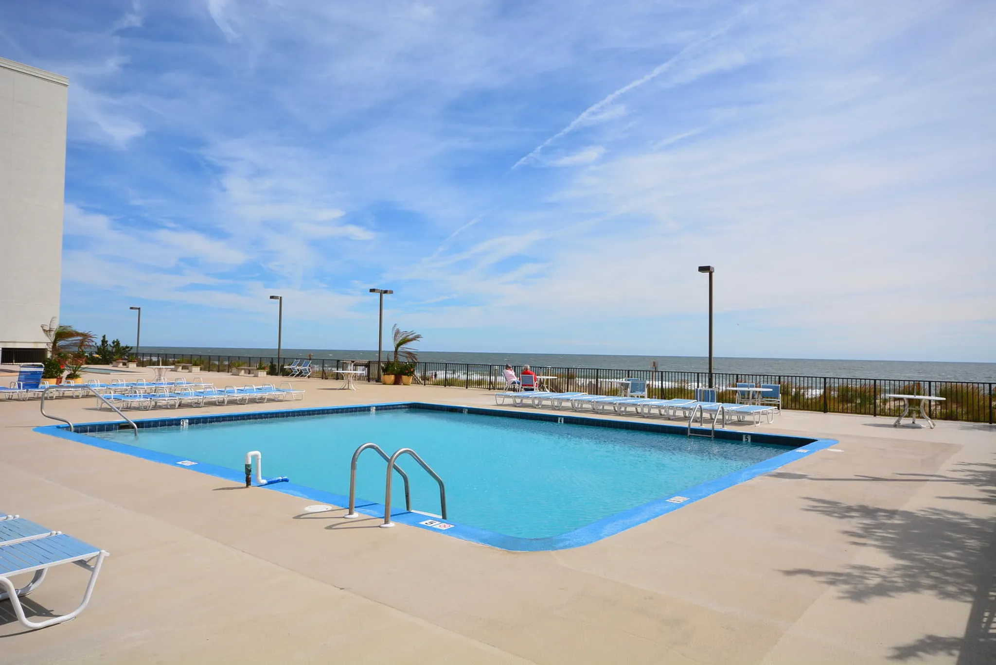 The 9400 Building's outdoor pool with lounge chairs and the Atlantic behind it