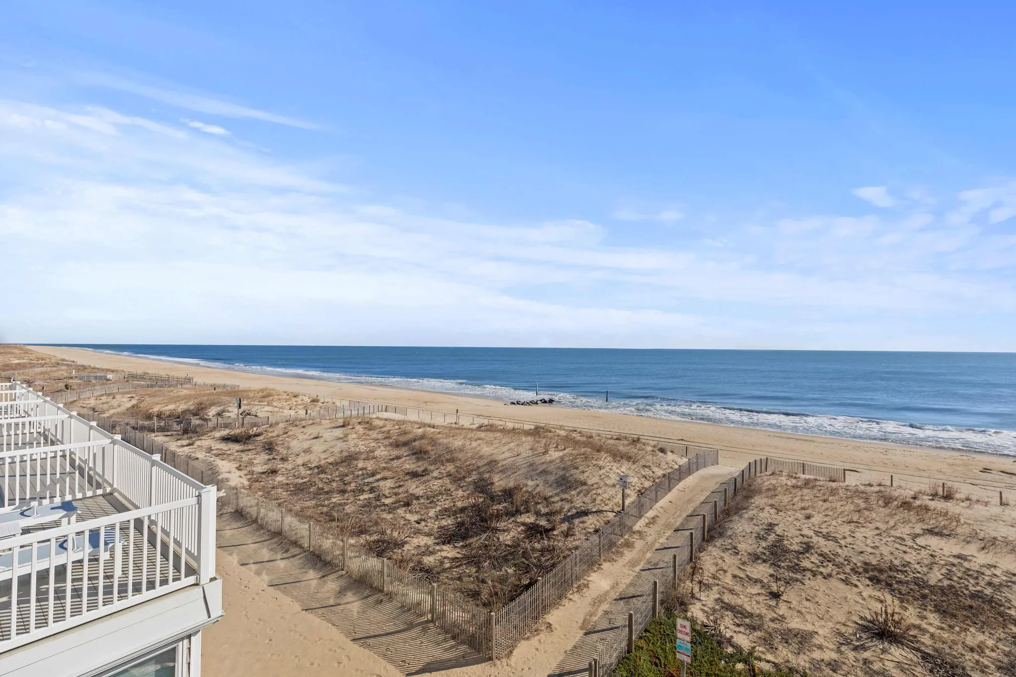 The beach and dune line at 46th Street seen over a Salty Sands balcony railing
