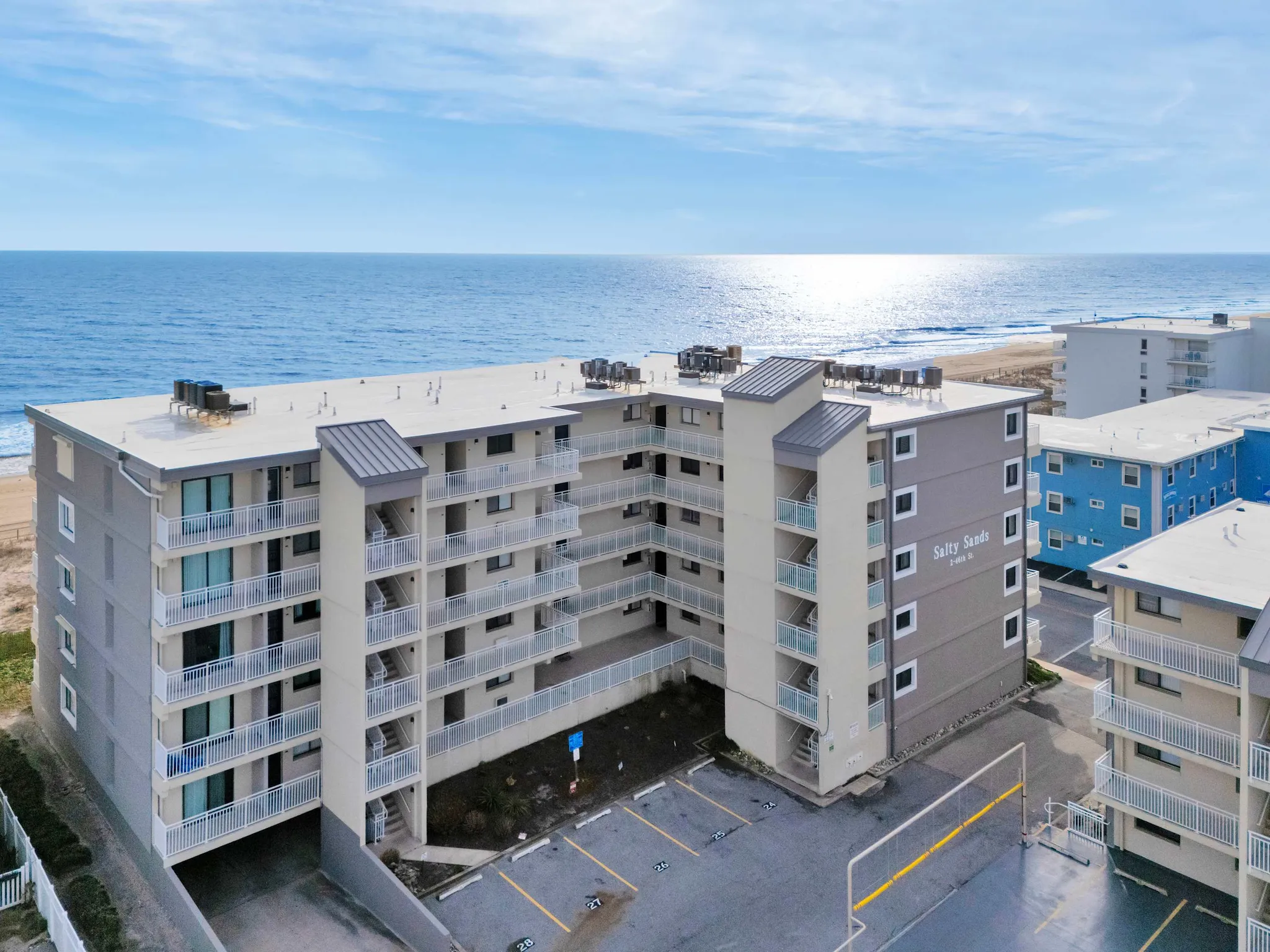 The Salty Sands building at 46th Street with its ocean-facing balconies and the volleyball court in front