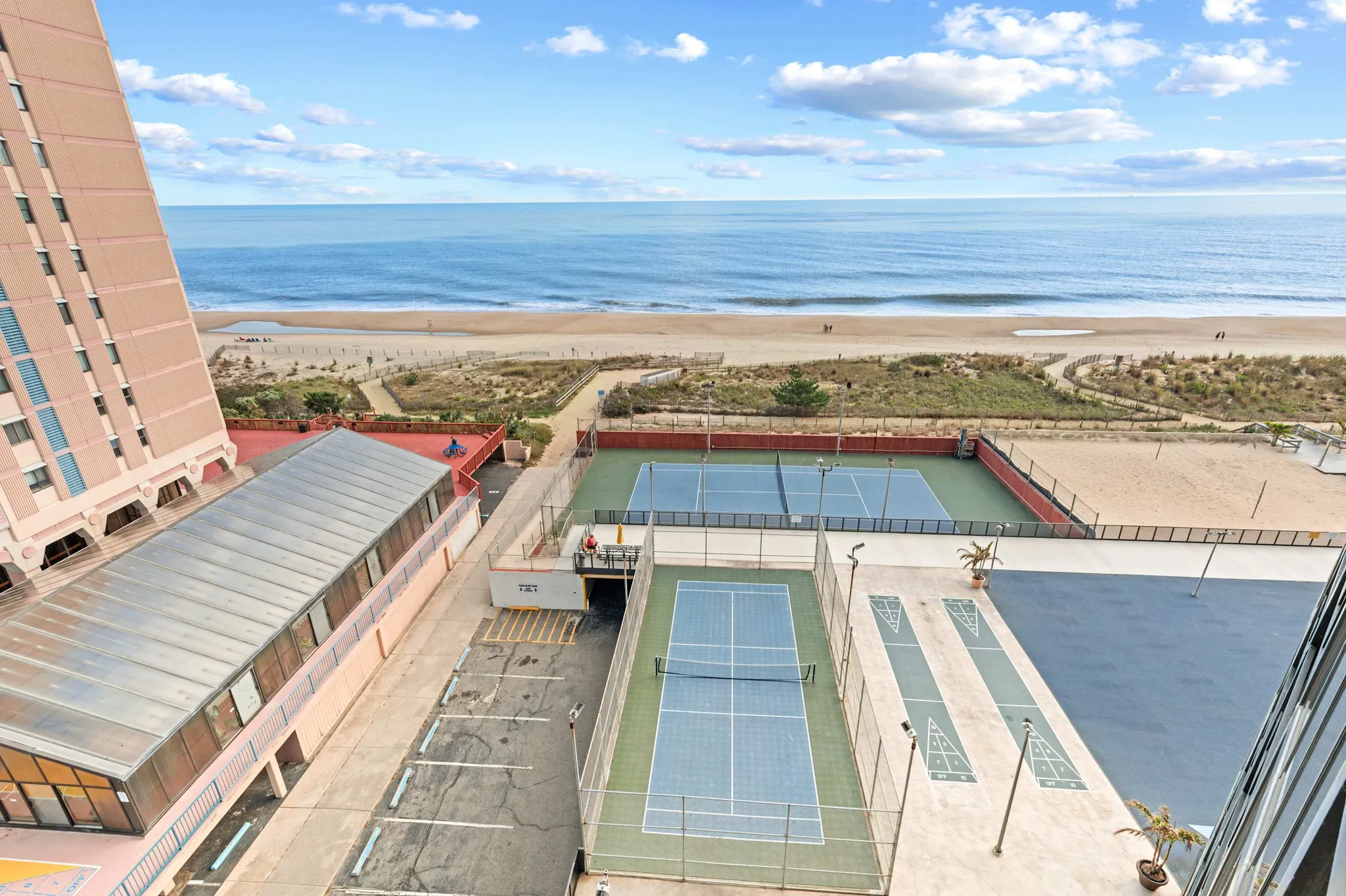 The beach, tennis courts and sundeck behind Golden Sands seen from an upper-floor balcony