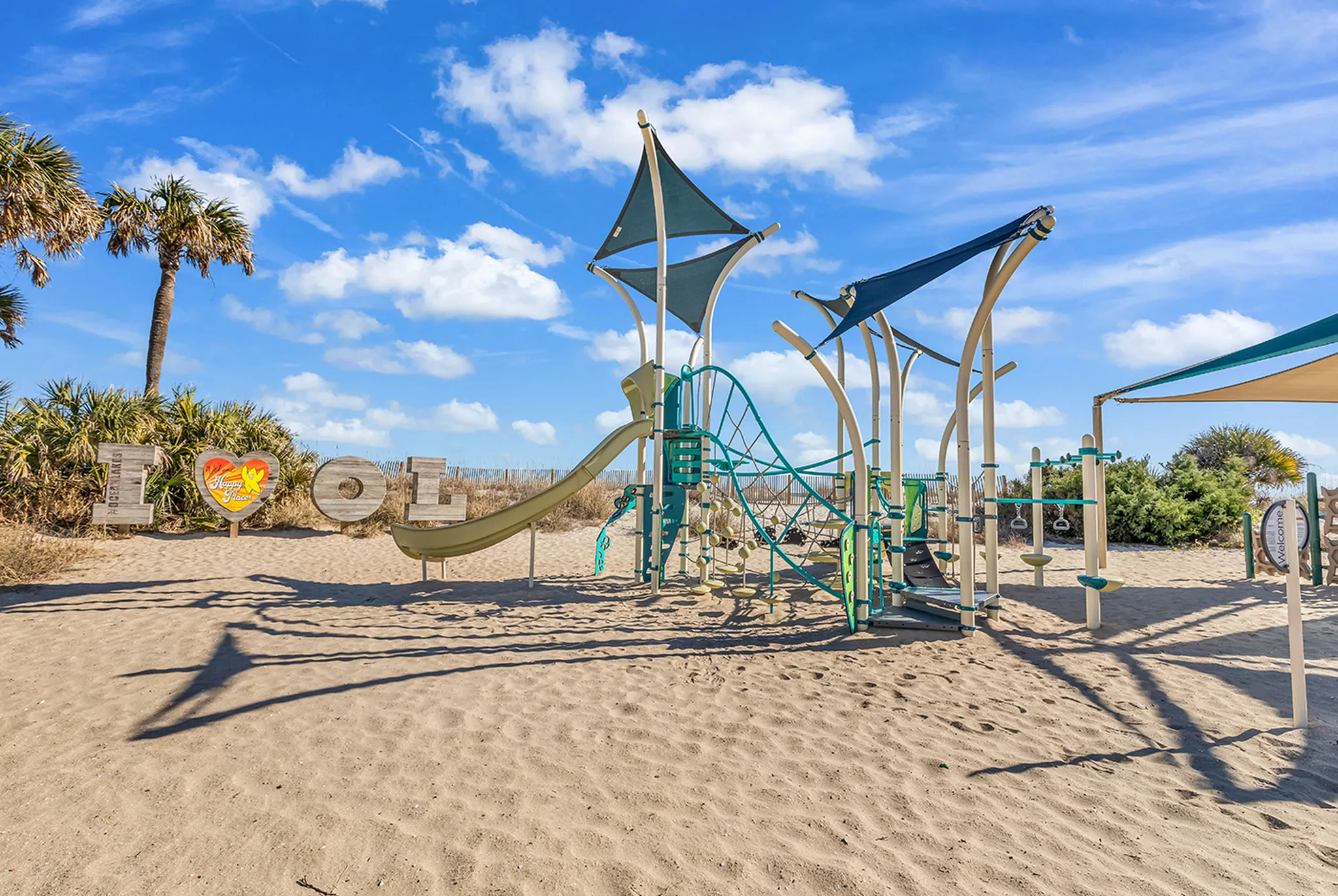 Shaded playground on the sand inside Ocean Lakes, a short walk from the private beach