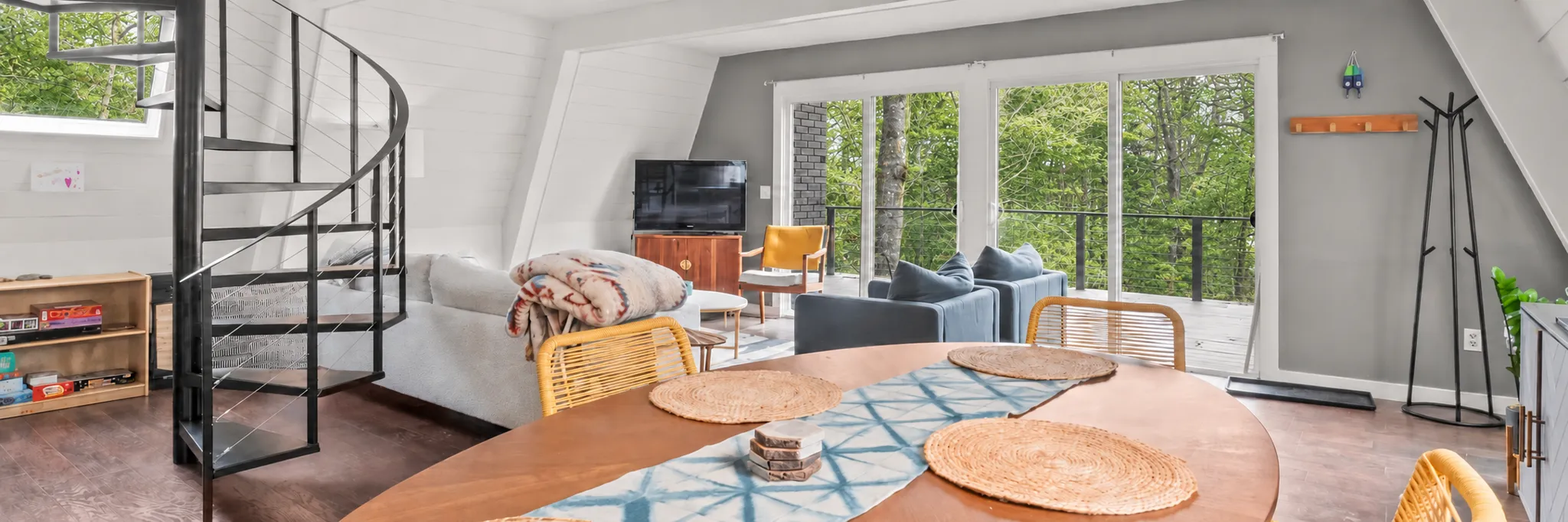 Open living and dining room with a spiral staircase
