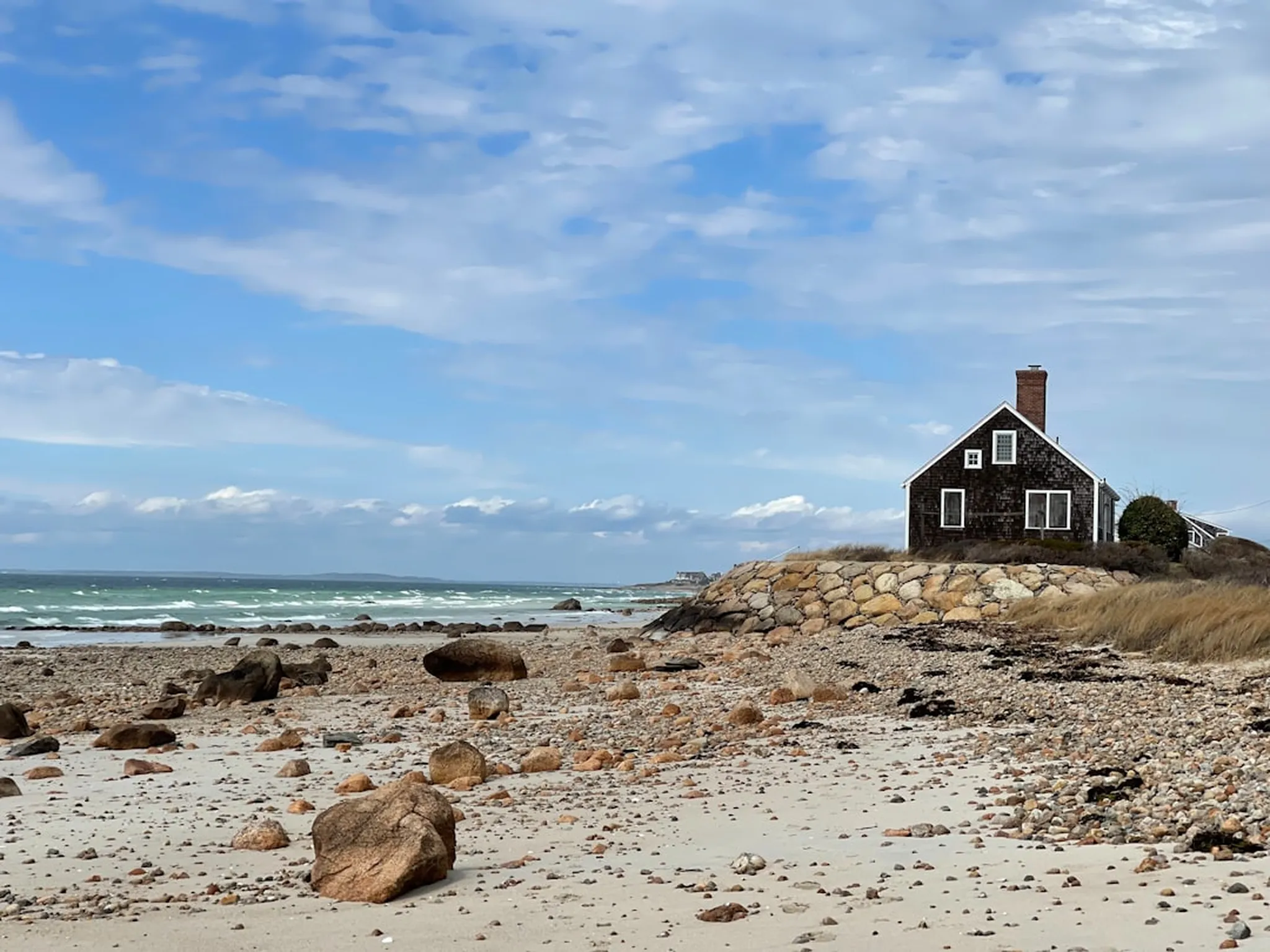 Shingled cottage by a rocky shoreline