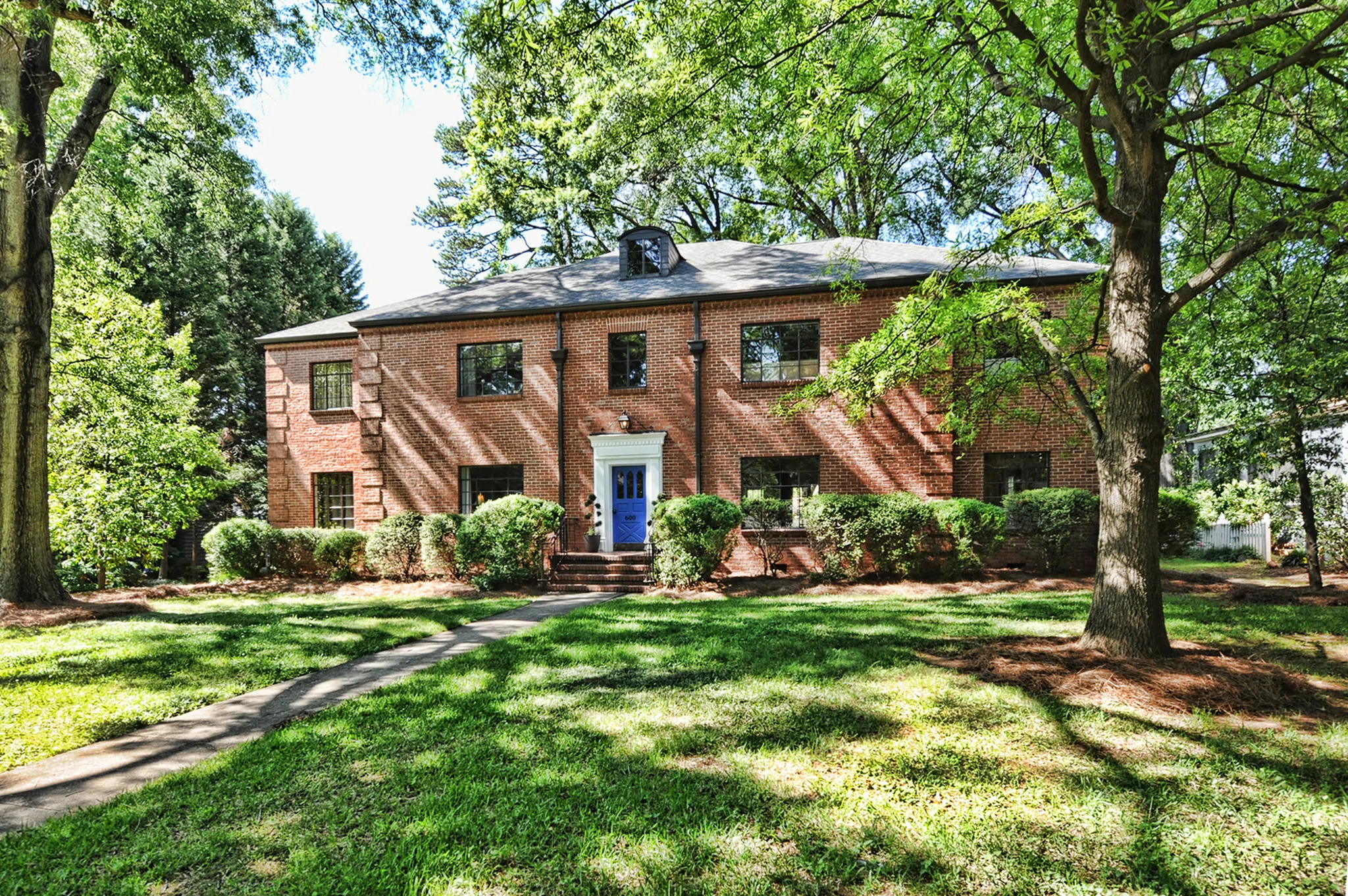 Bright, airy living room with original hardwood floors and soft neutral furnishings in a historic Charlotte condo