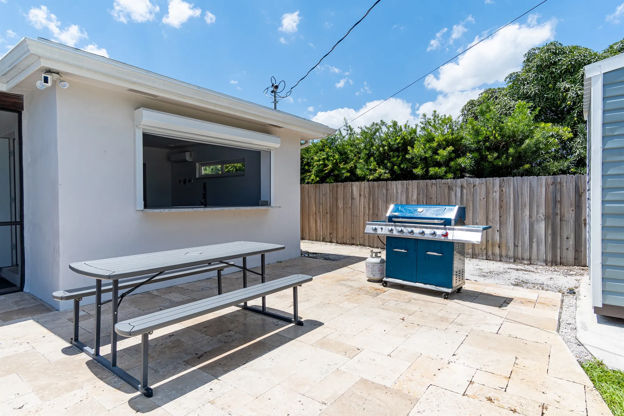 The backyard grill, outdoor dining table, and heated pool