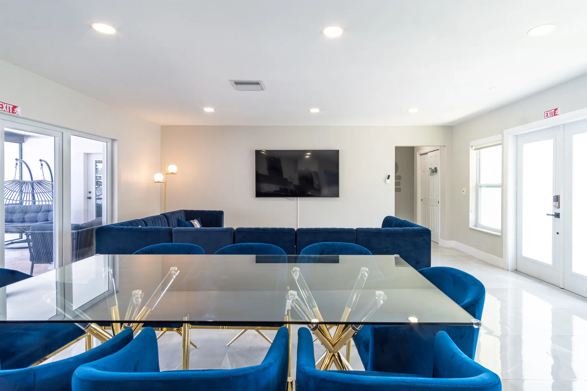 Living room with blue velvet sectionals and sliding doors to the patio