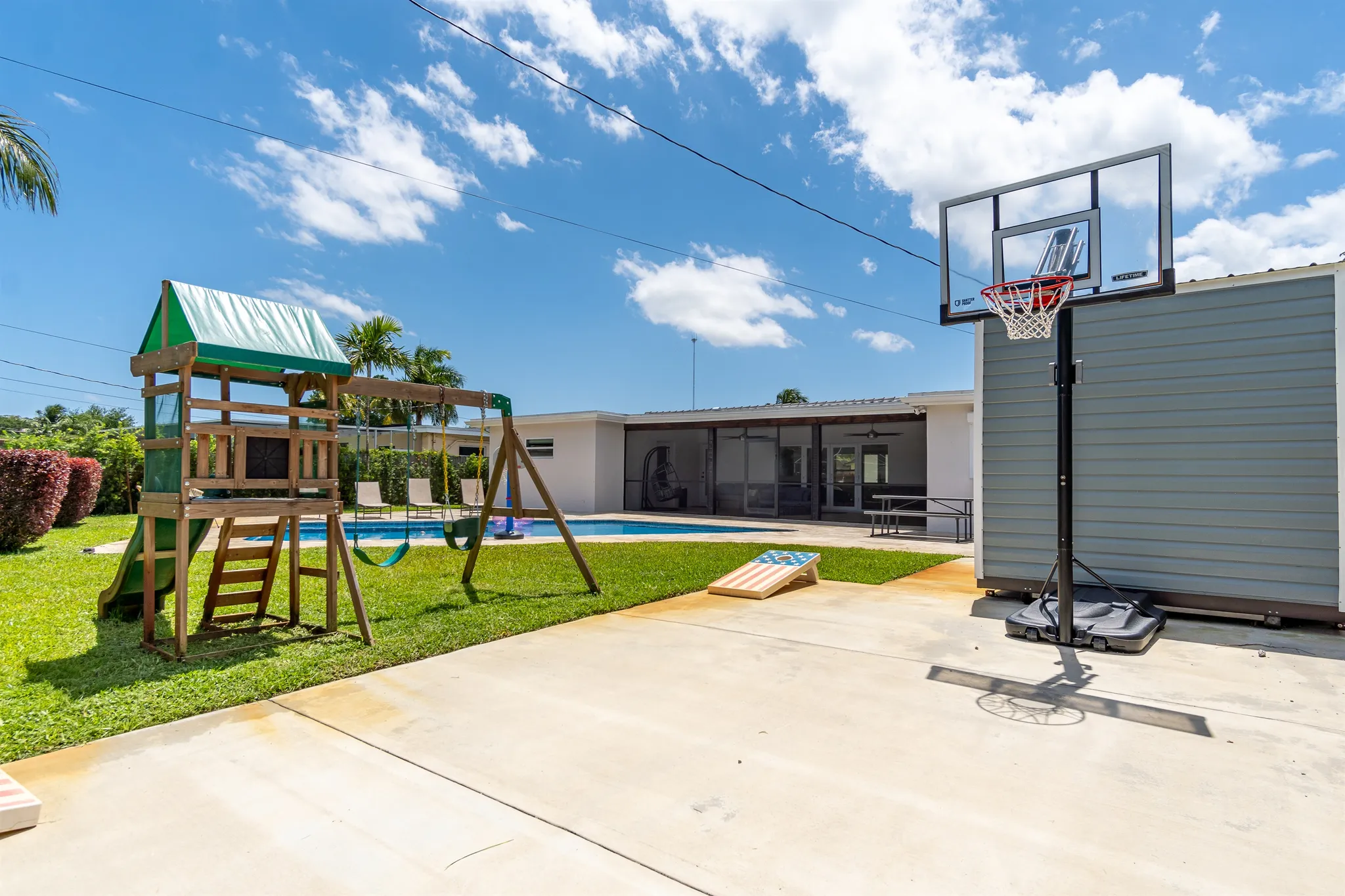 Backyard with the pool, playground, and lawn