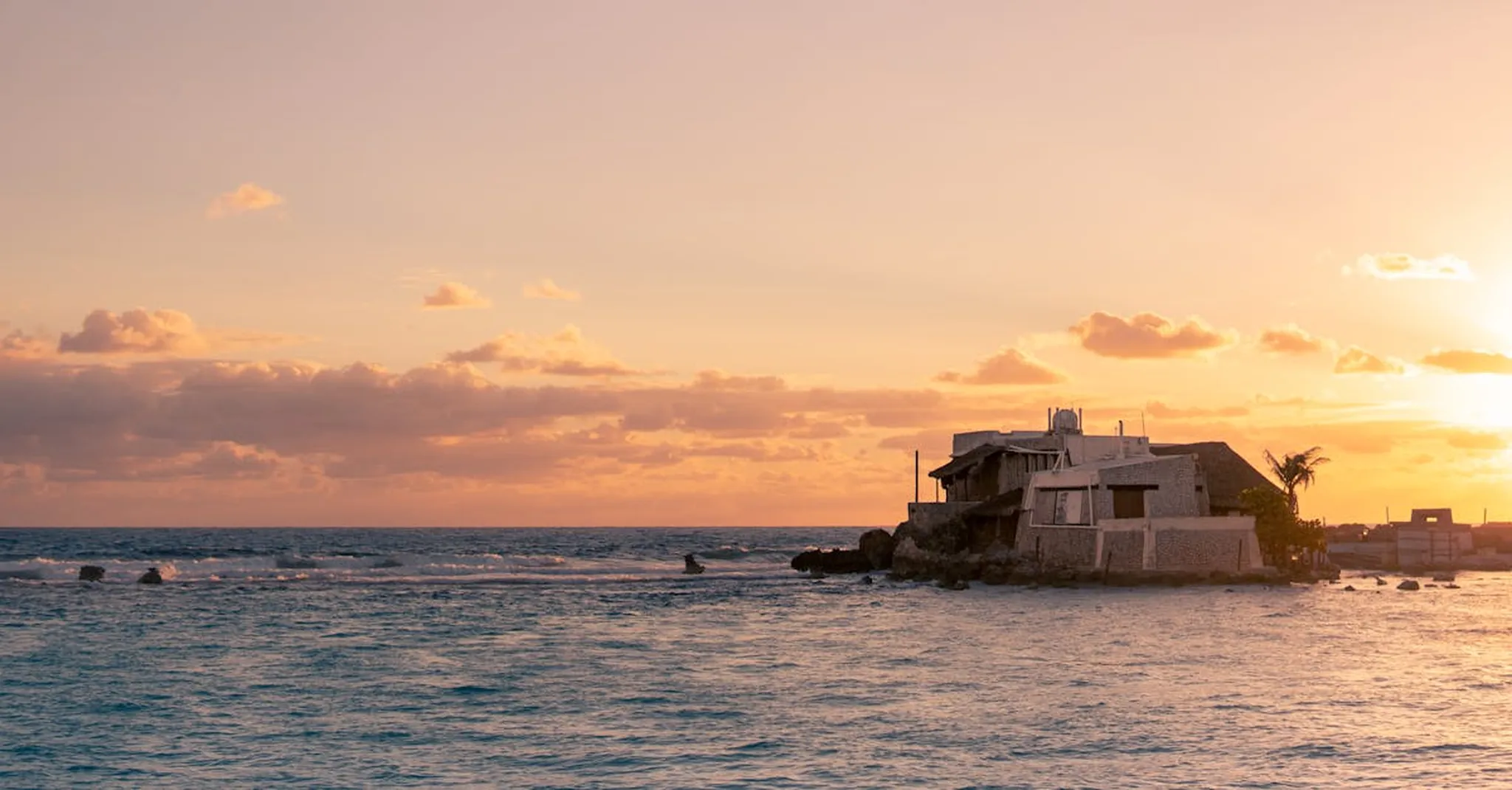 Golden sunset over a picturesque seafront villa on Isla Mujeres, Quintana Roo, Mexico.