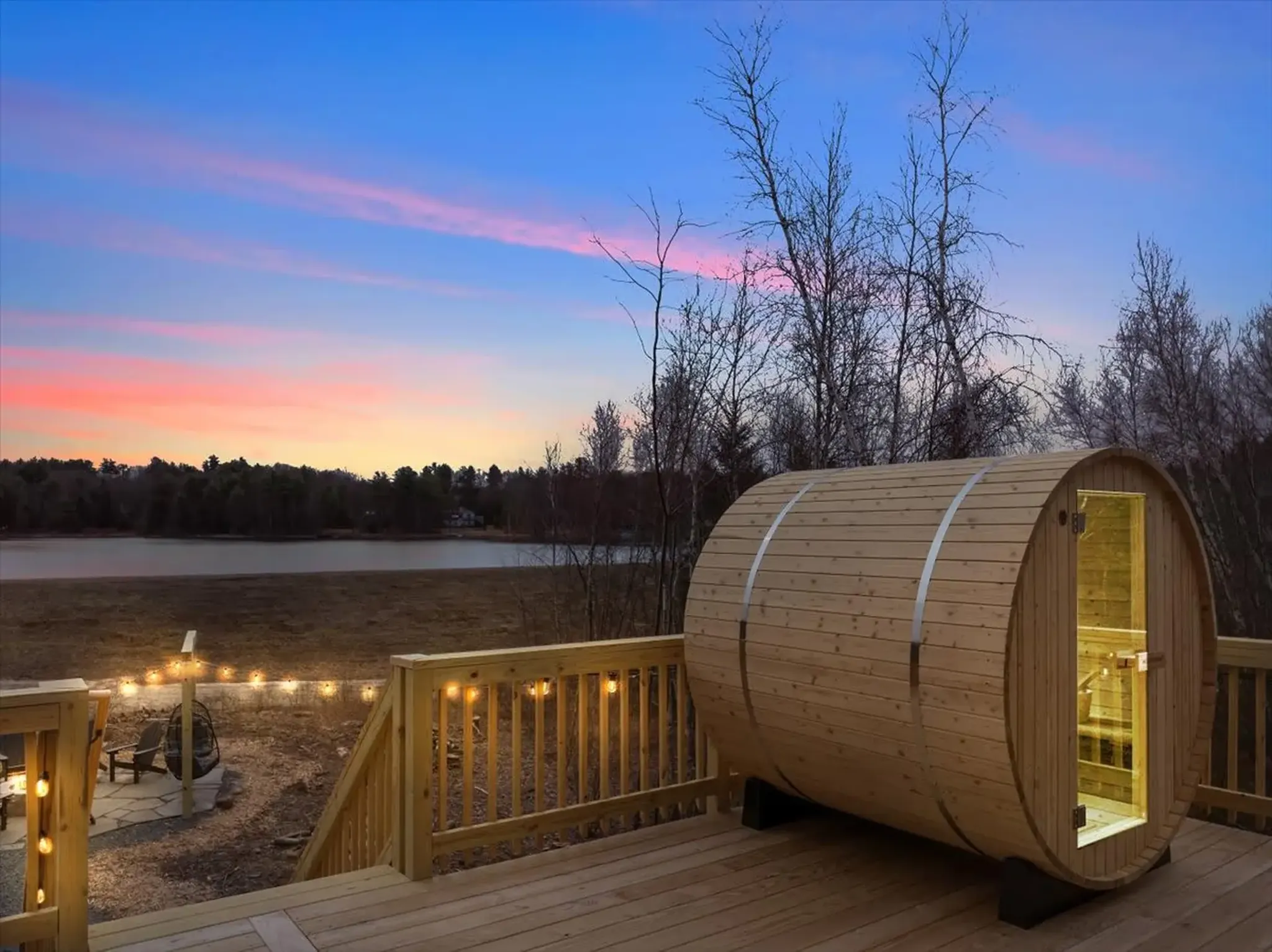 Outdoor barrel sauna on a wooden deck with sunset views at a mountain cabin rental at the poconos