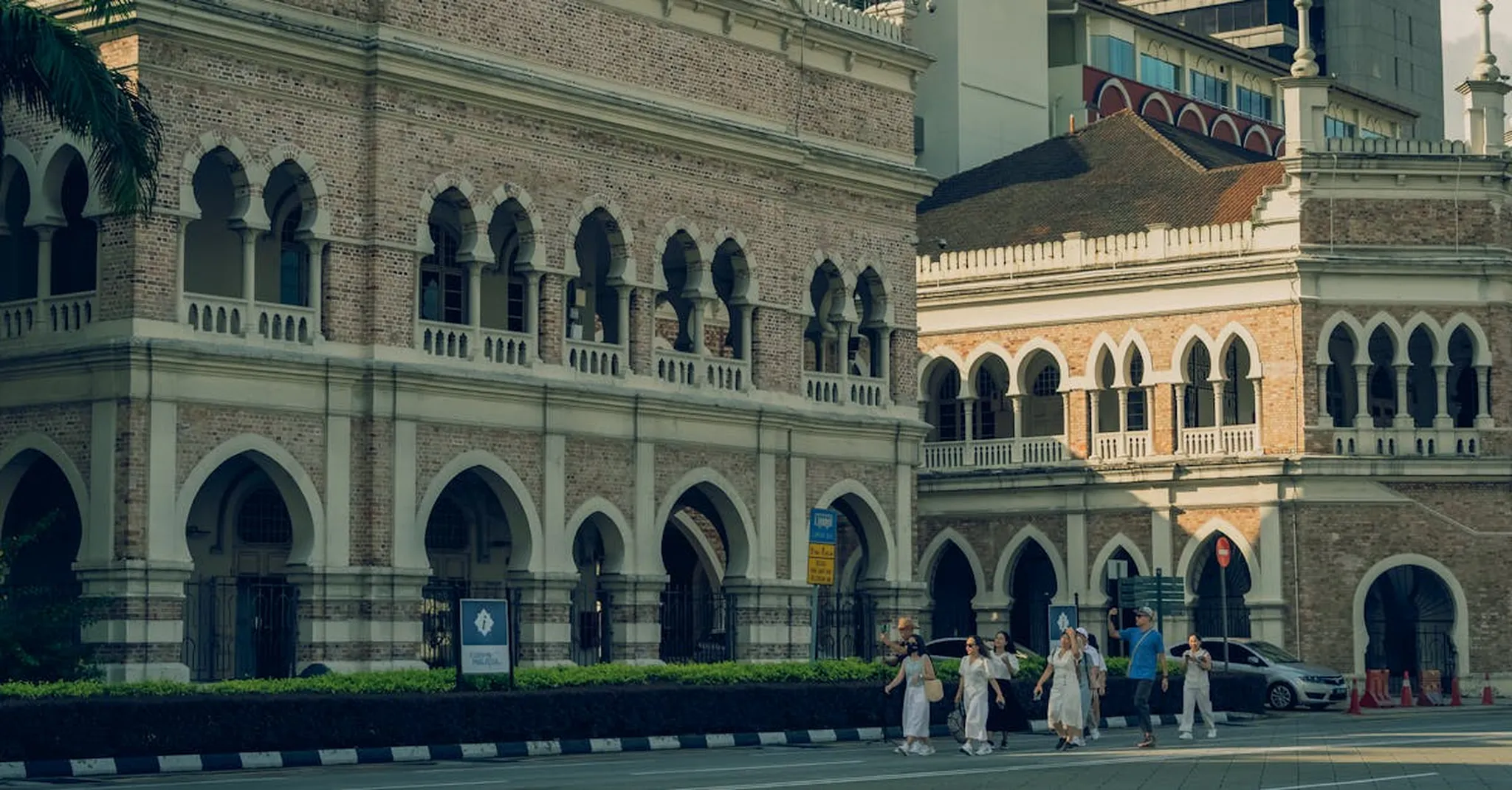 A view of historic architecture and people walking in Kuala Lumpur, Malaysia.