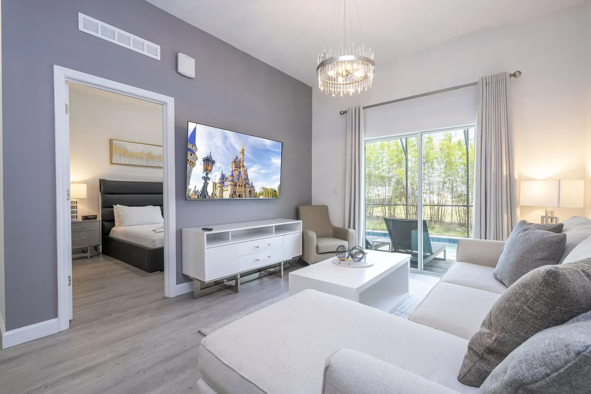 photo of living room with pool in back patio