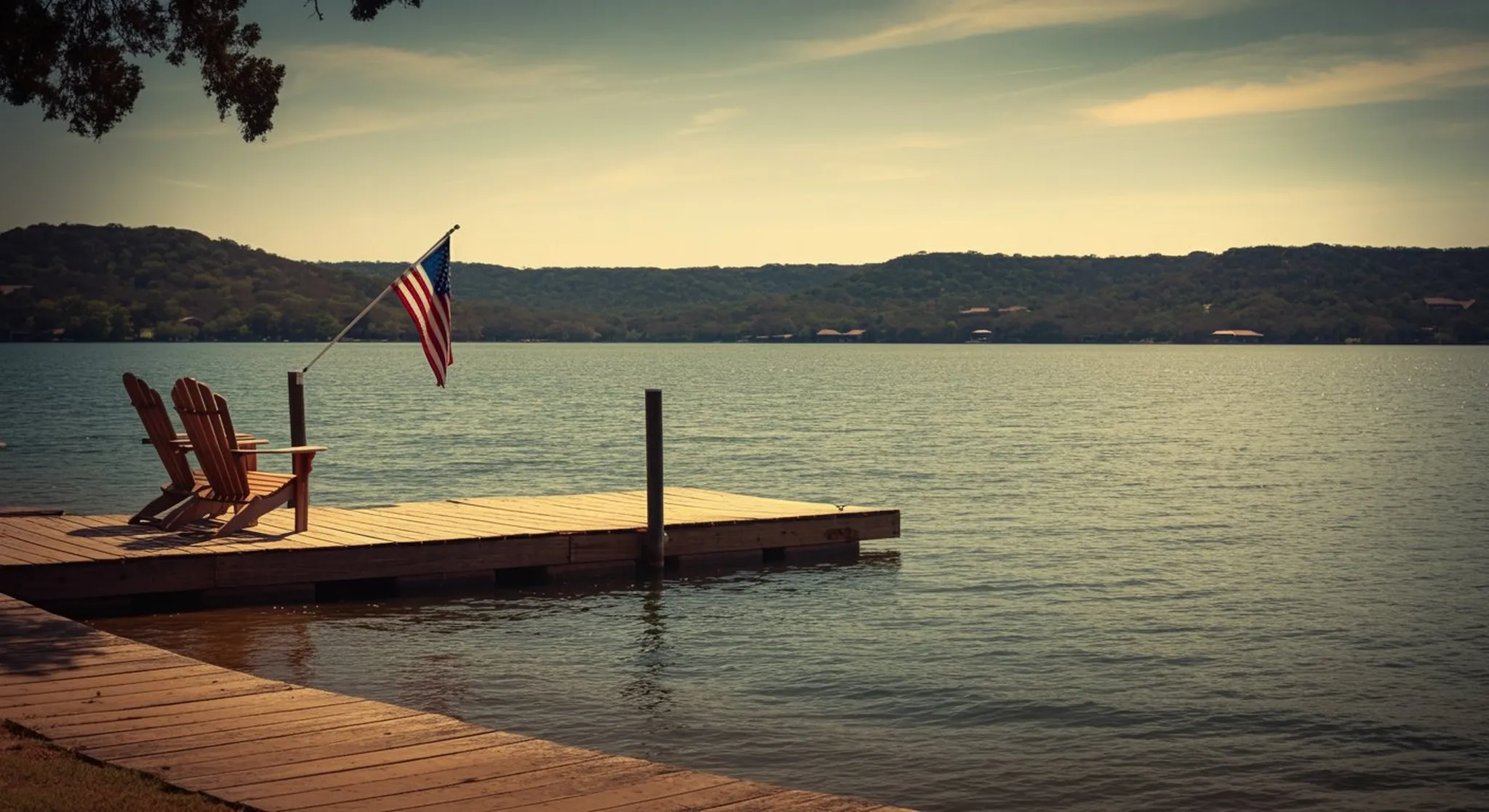 Texas Hill Country lake at golden hour with a wooden dock, Adirondack chairs, and a small American flag