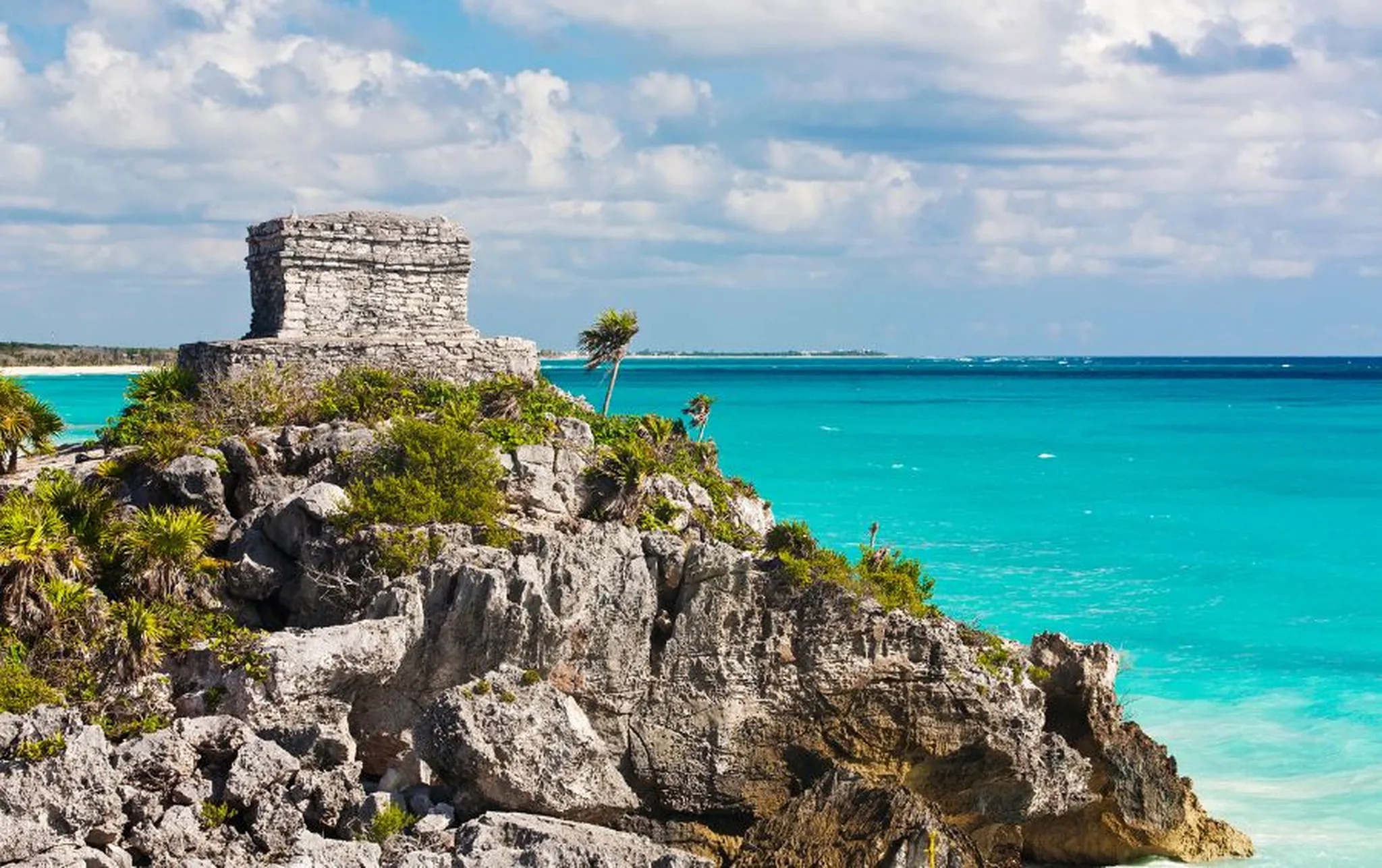 The ancient Mayan ruins of Tulum sitting on a cliff overlooking a turquoise sea