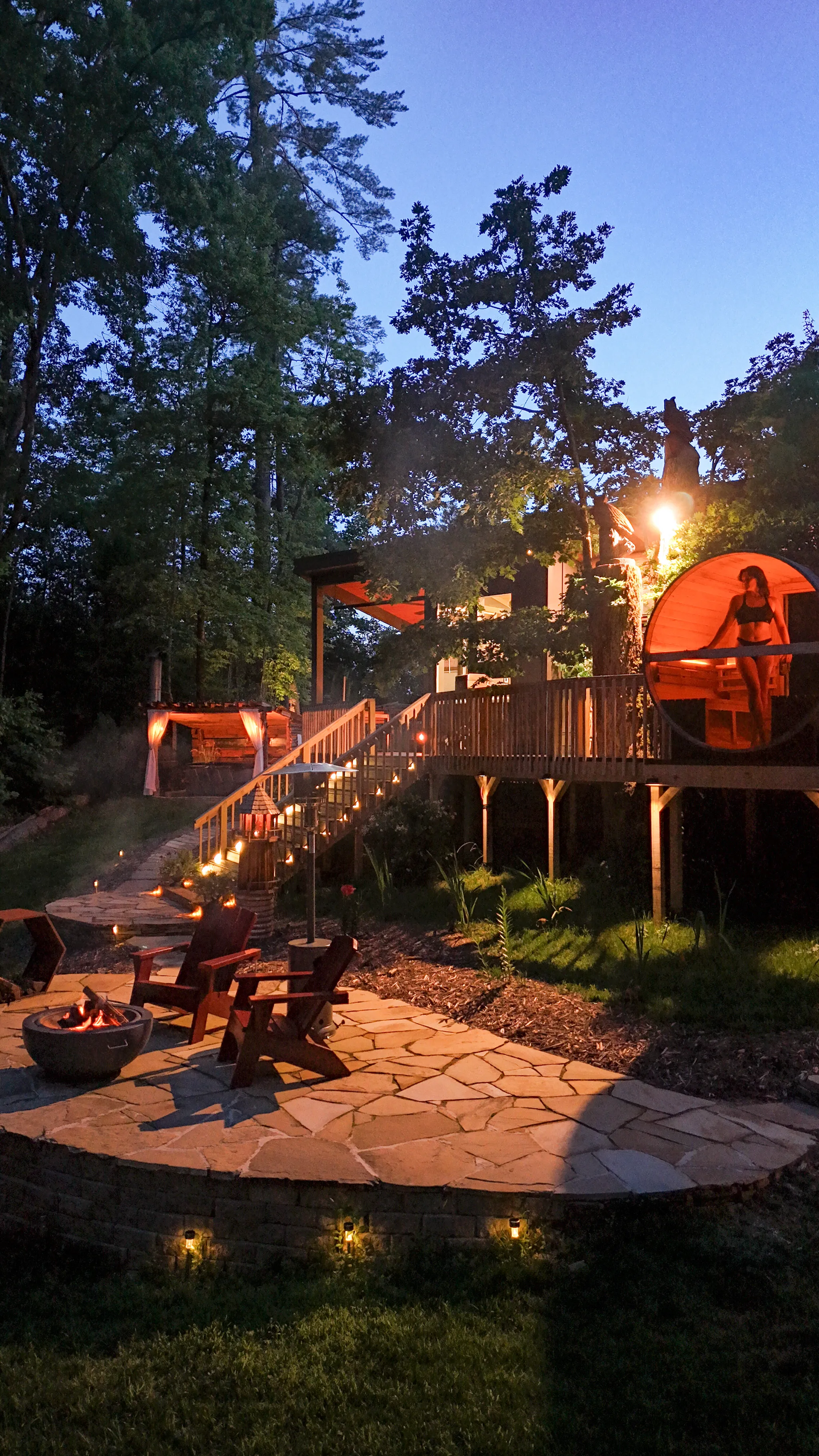 Wooden barrel sauna and outdoor shower on a deck.