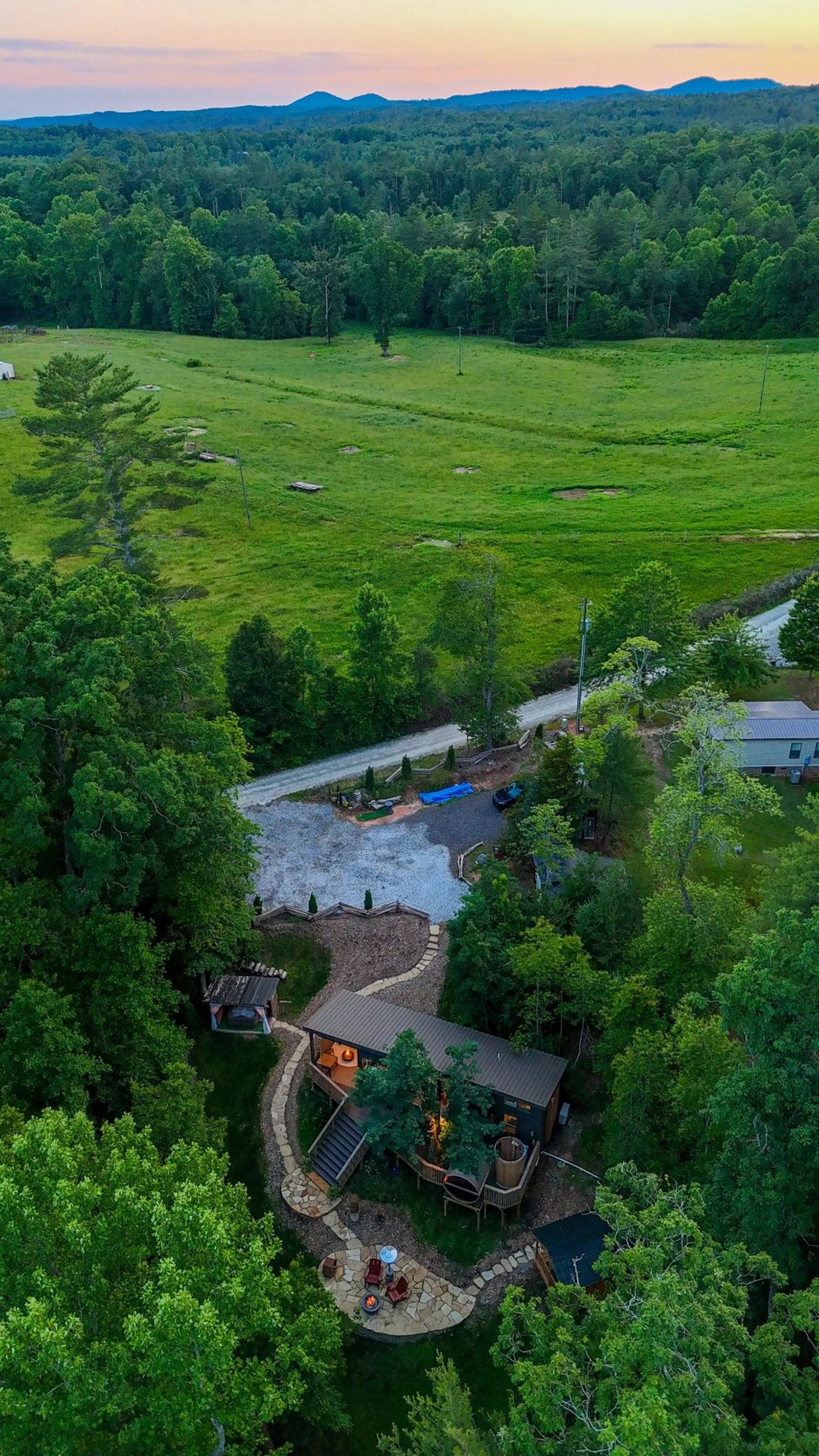 a landscape with trees and bushes a cow pasture green field with a modern cabin