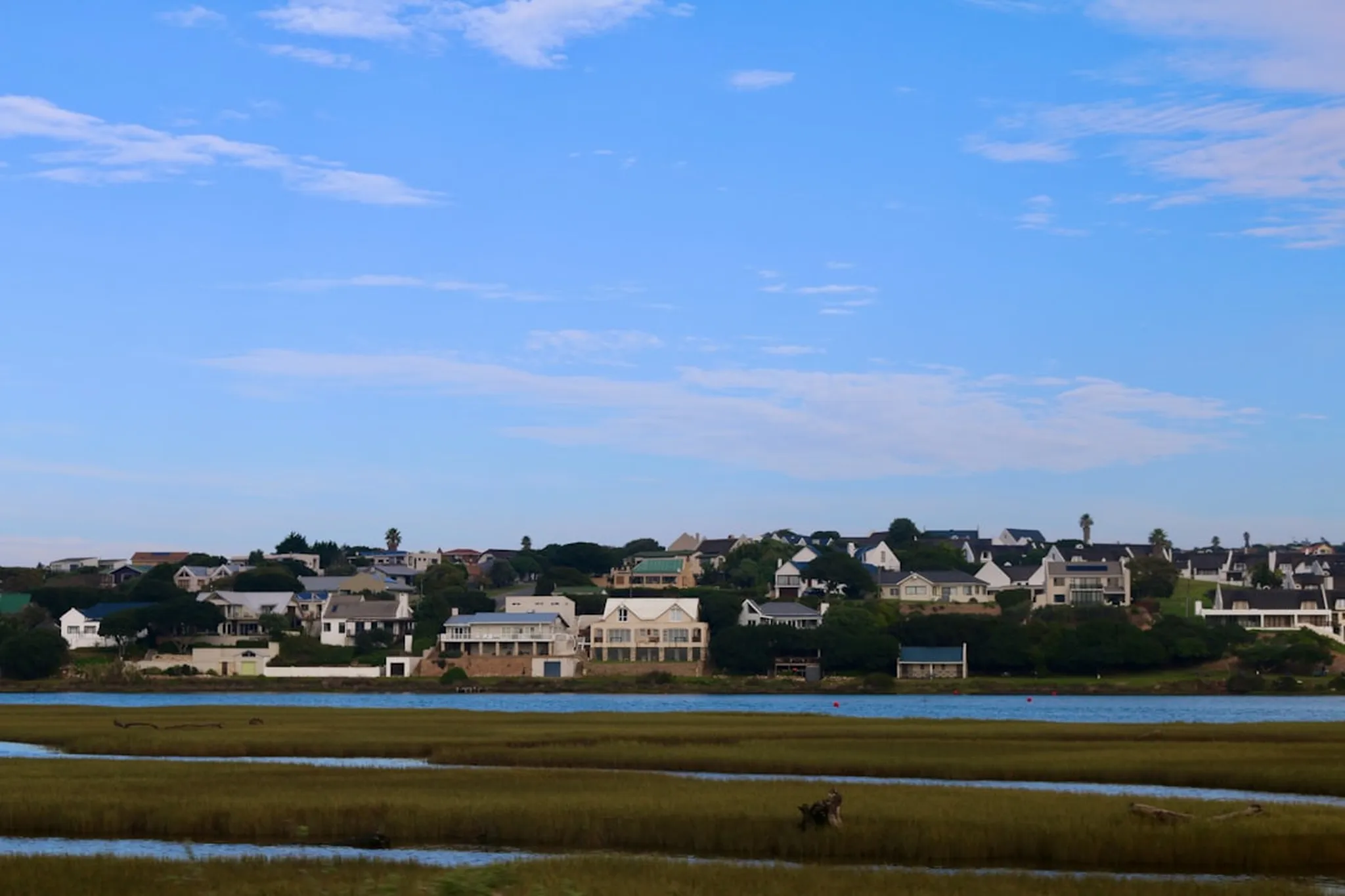 A body of water with houses in the background
