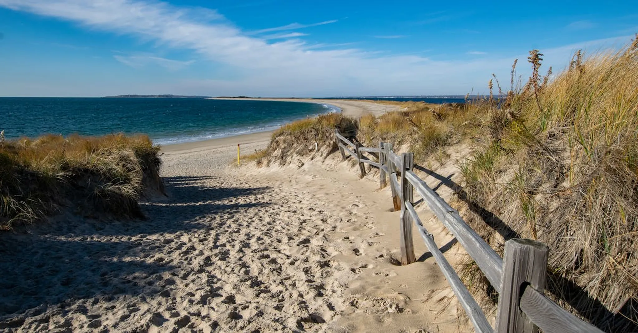 Discover a serene sandy path leading to the ocean in Westerly, Rhode Island.