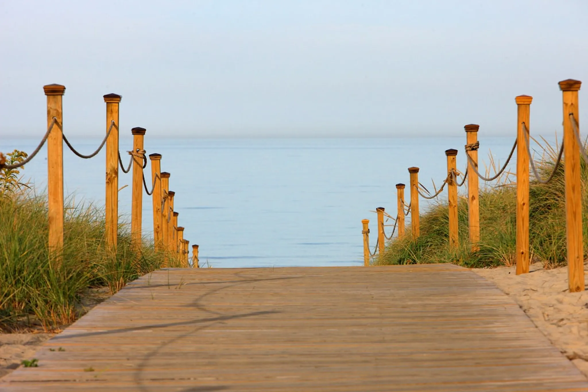 a wooden walkway leading to the ocean