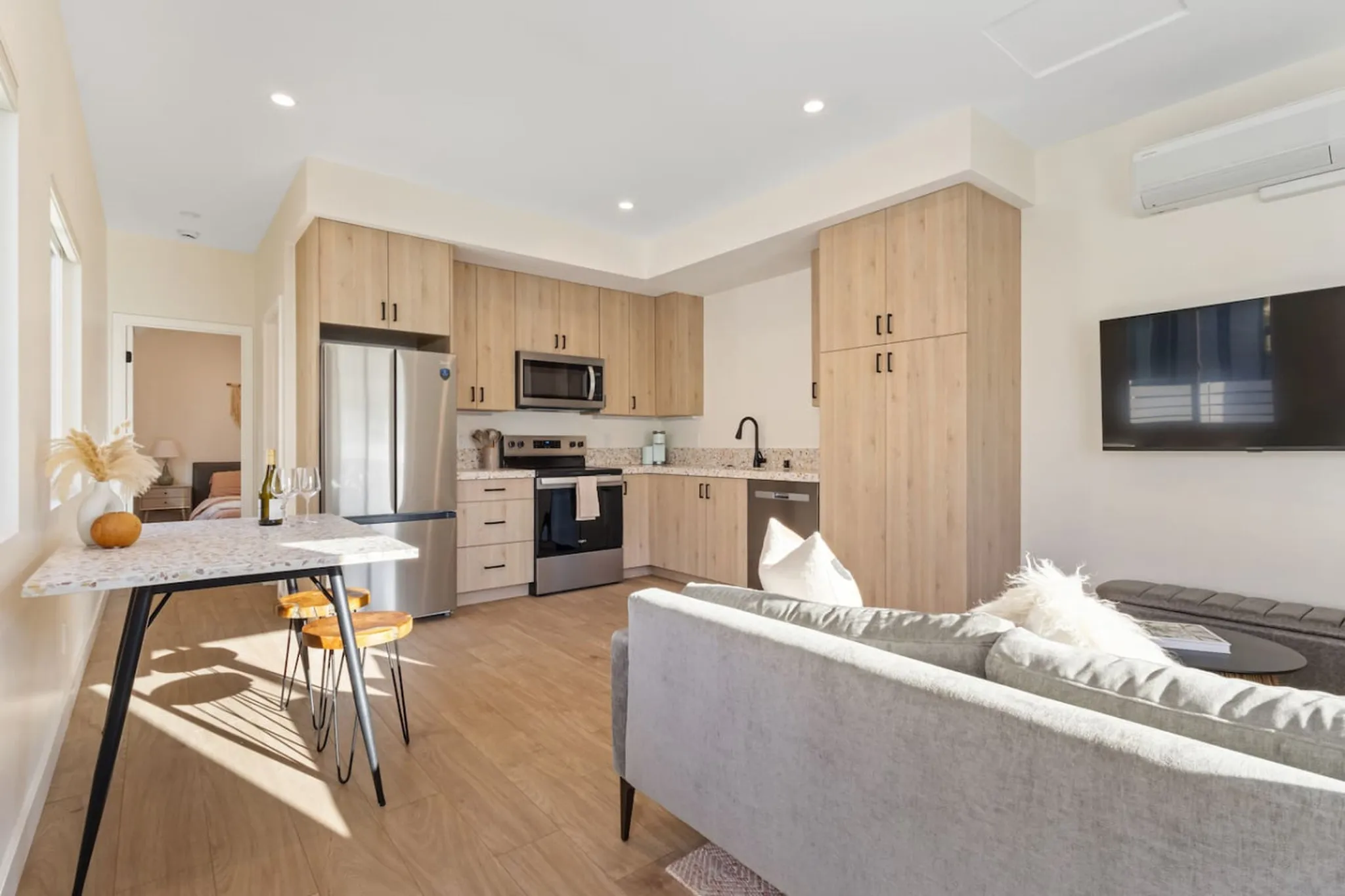 Bright open concept living area with European style cabinets, stainless appliances, Terrazzo countertops and high-end modern furnishings.
